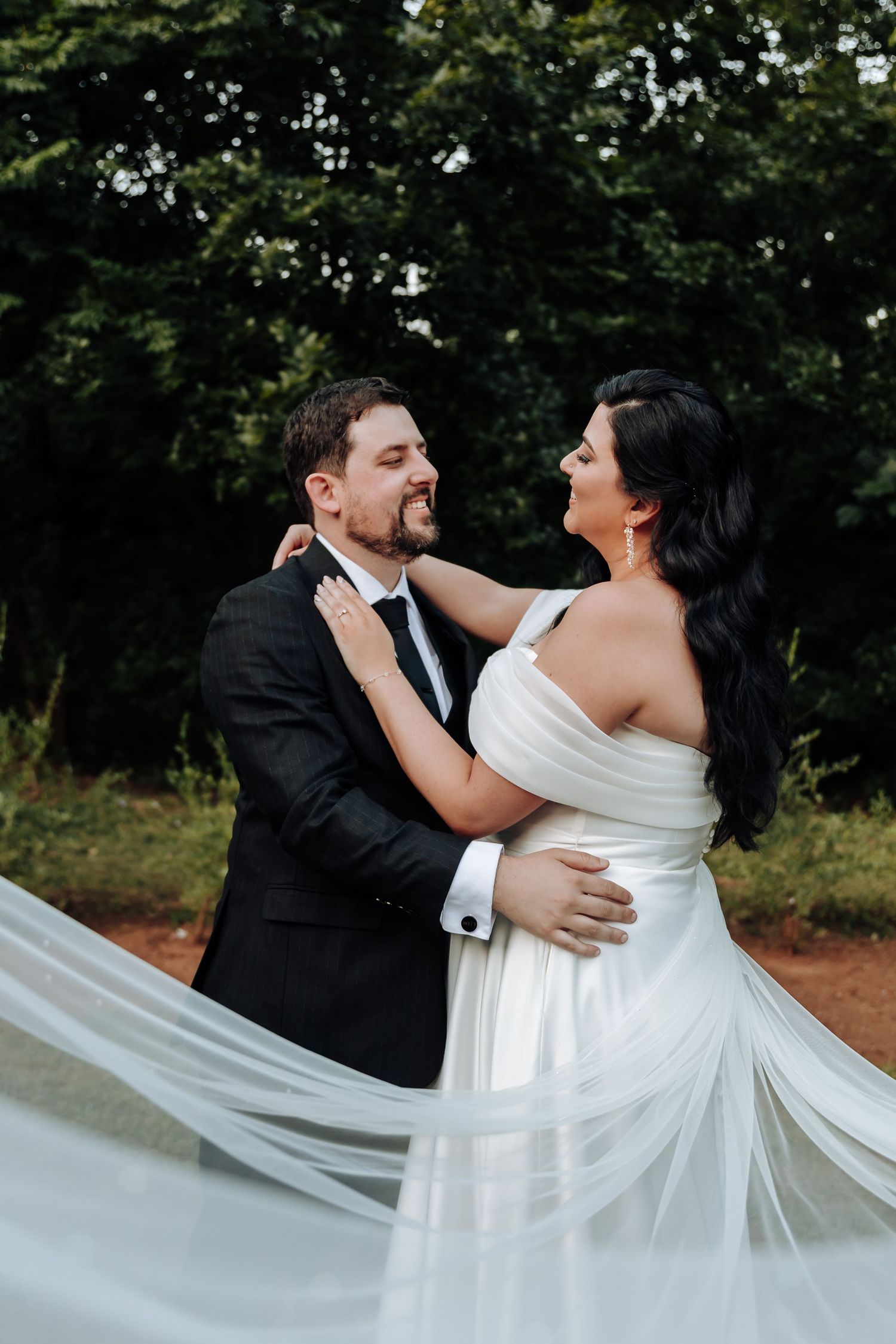 Couple shares intimate dance moment outdoors with flowing white dress movement.