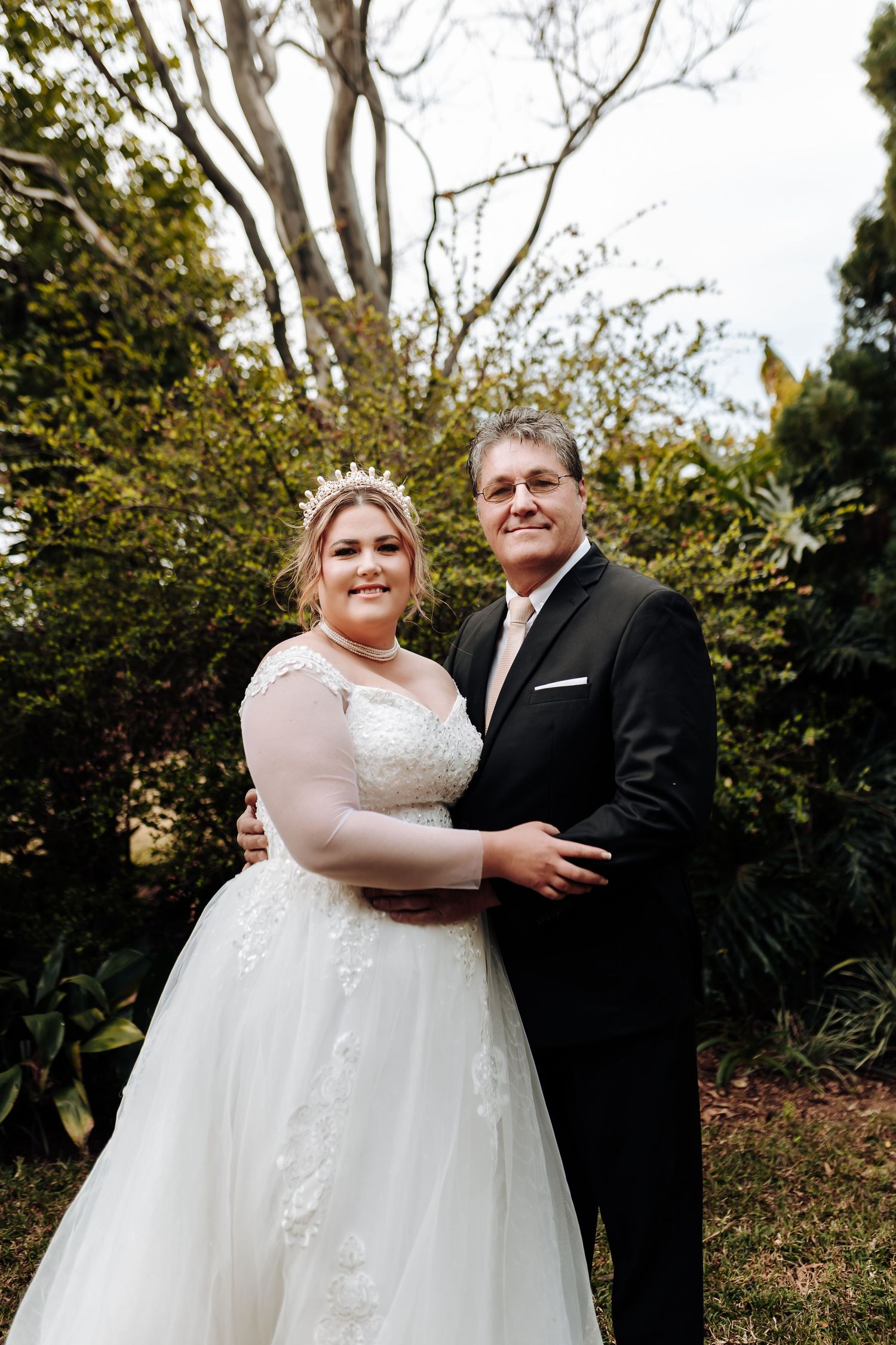 Happy couple shares an intimate embrace during their outdoor autumn wedding photoshoot.