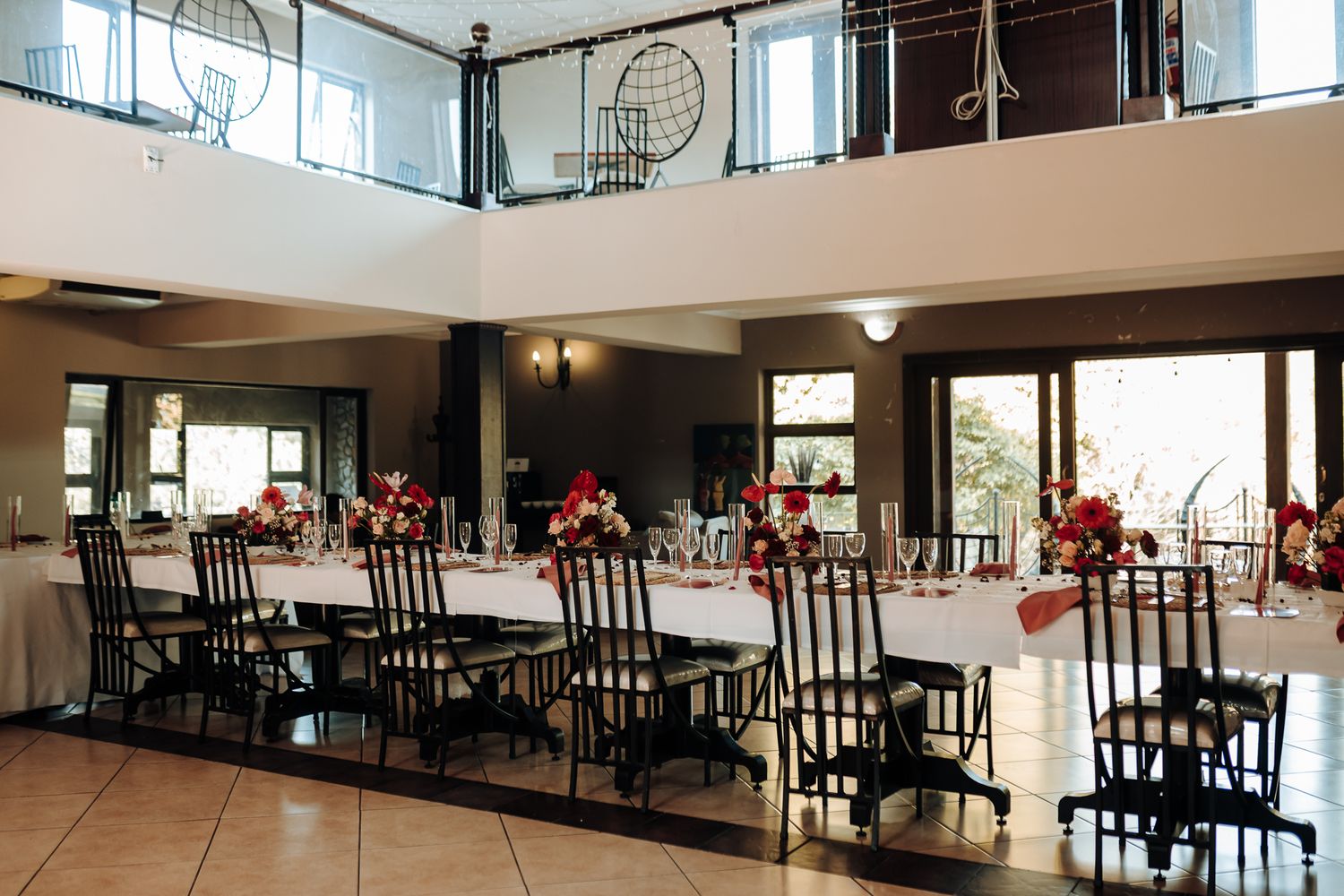 Modern wedding reception venue with black chairs and high ceilings.