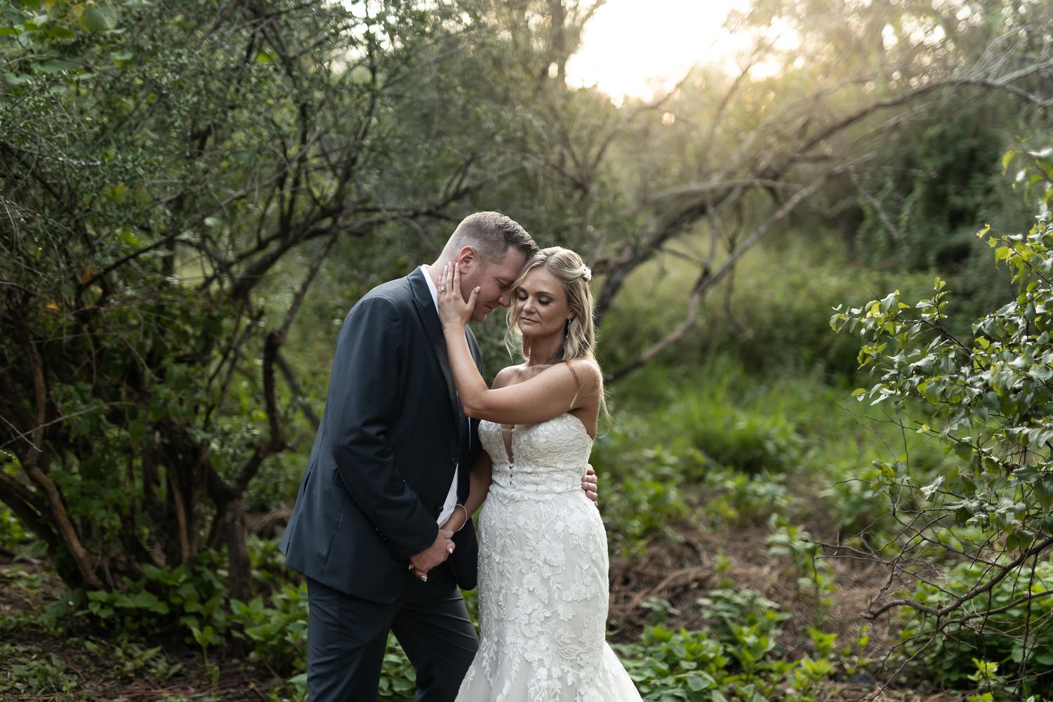 A sweet candid moment between newlyweds in a scenic outdoor garden.