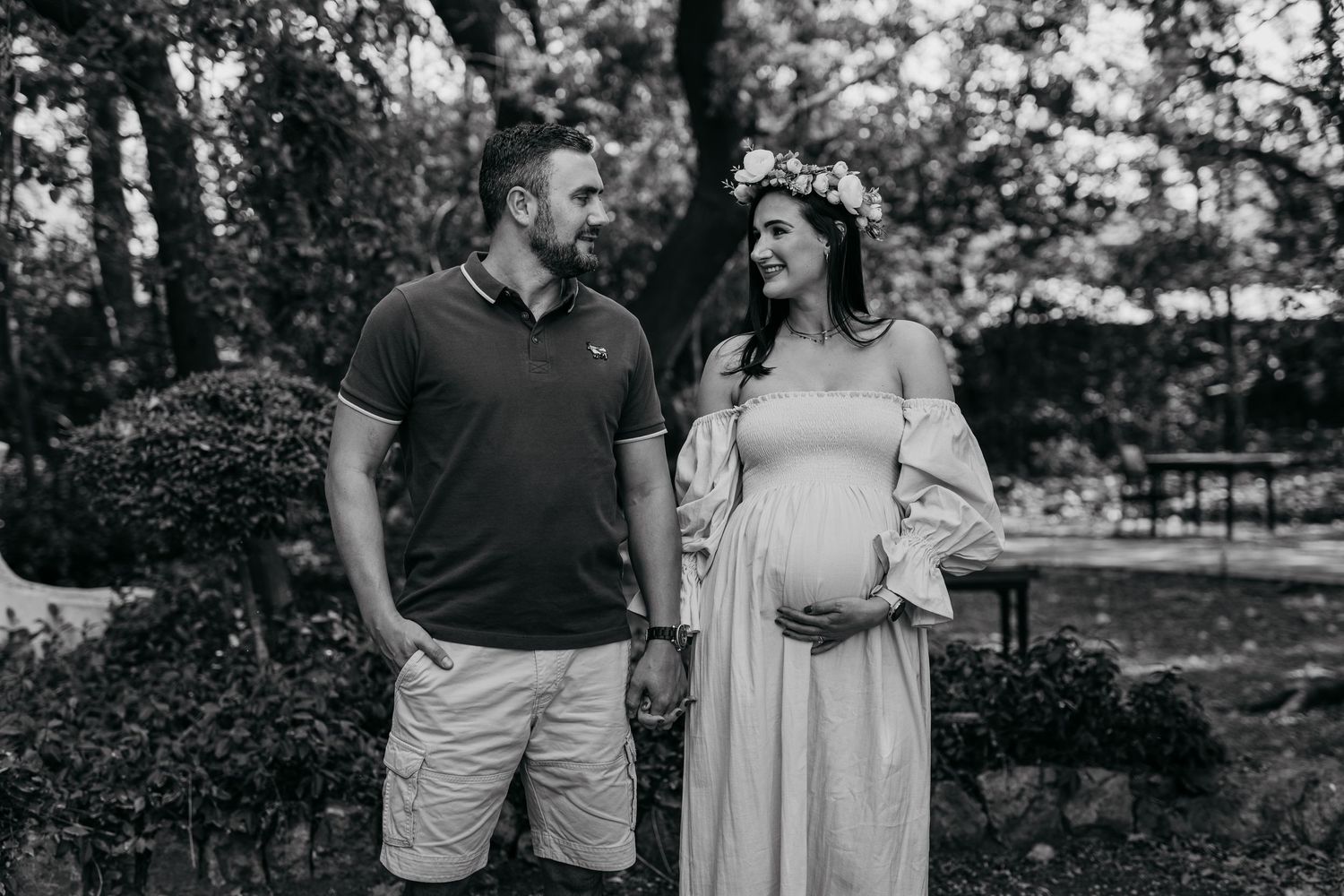 Happy couple poses together outdoors during romantic engagement photography session in a natural setting.