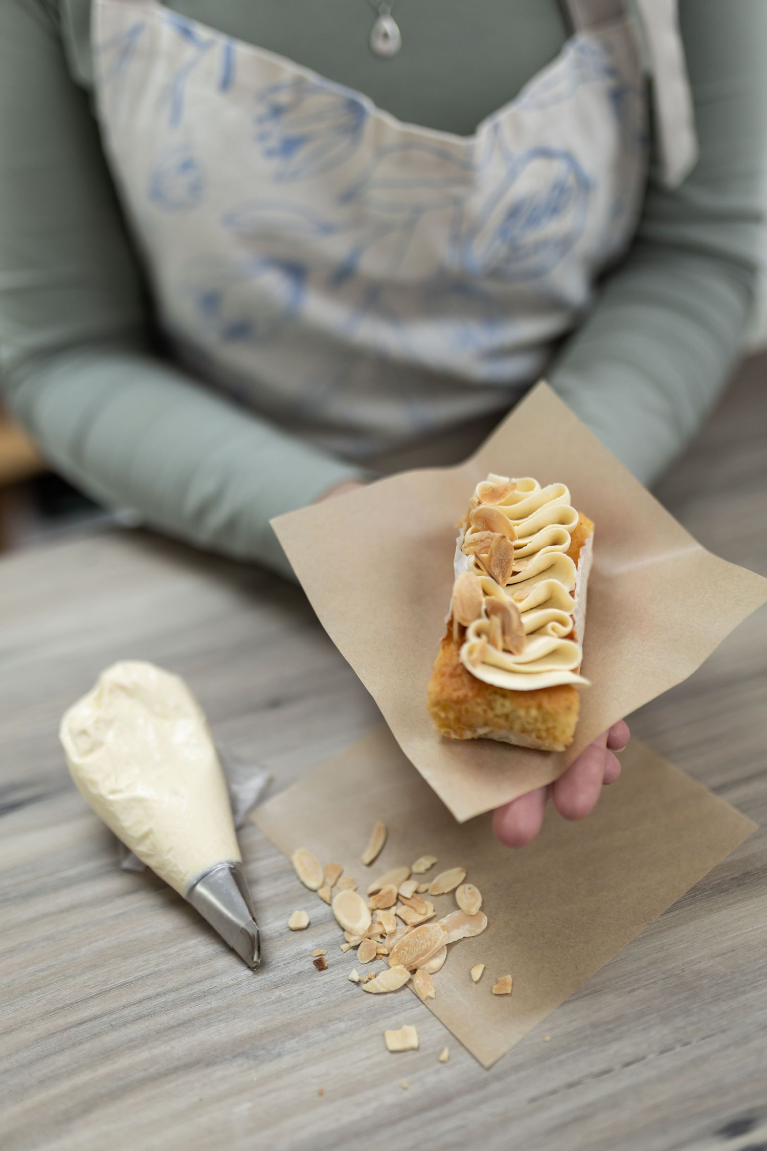 Homemade baklava dessert with flaky pastry layers and nuts being served on brown parchment paper.