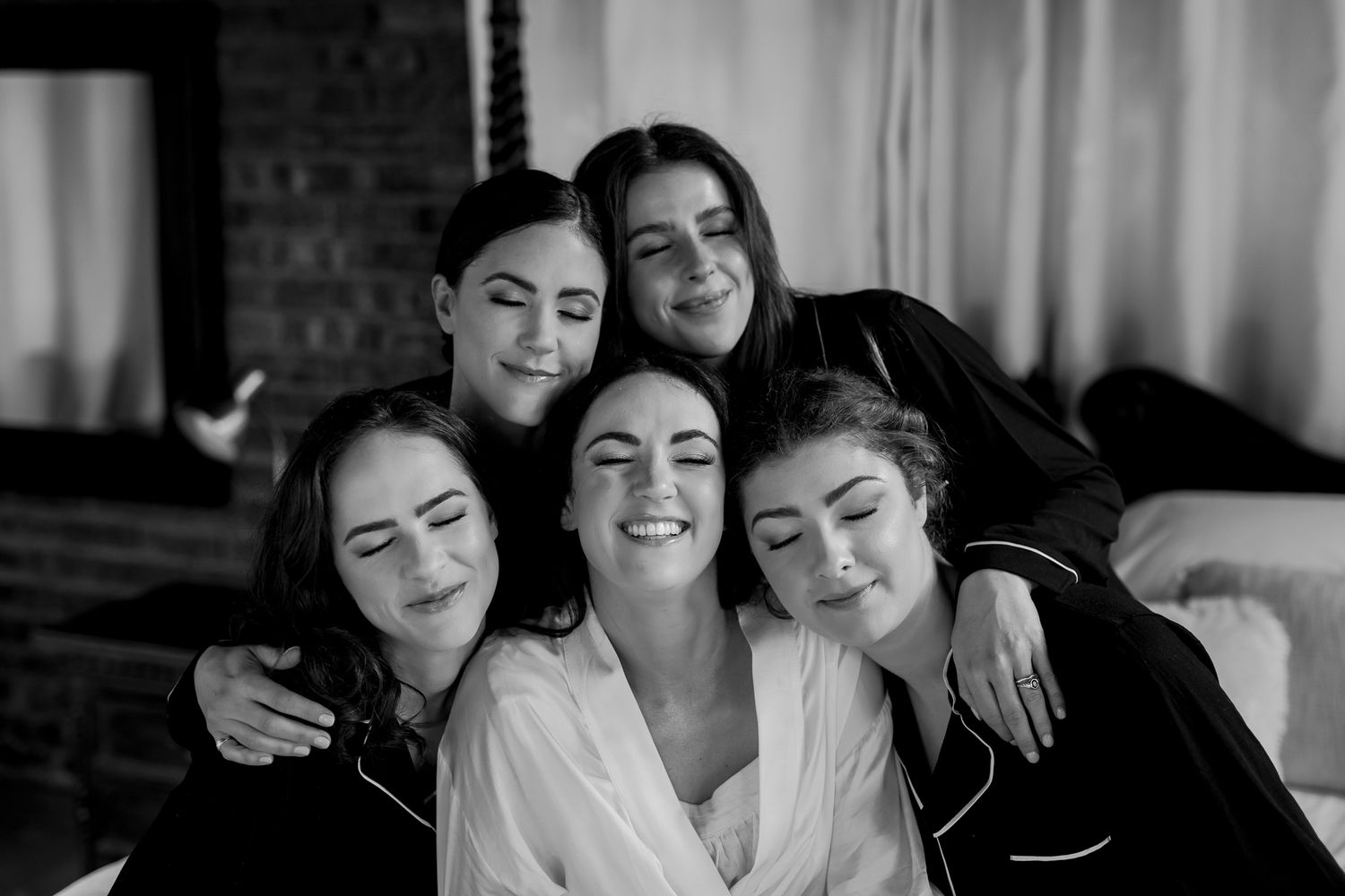 Group wearing matching robes pose together during wedding morning preparations.