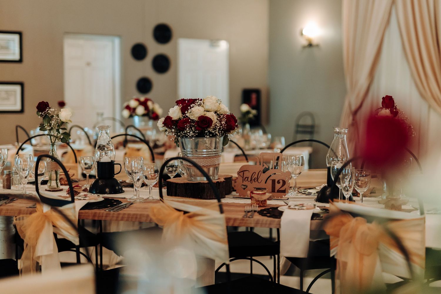 Rustic wedding reception venue with black chairs and peach-colored decor elements.