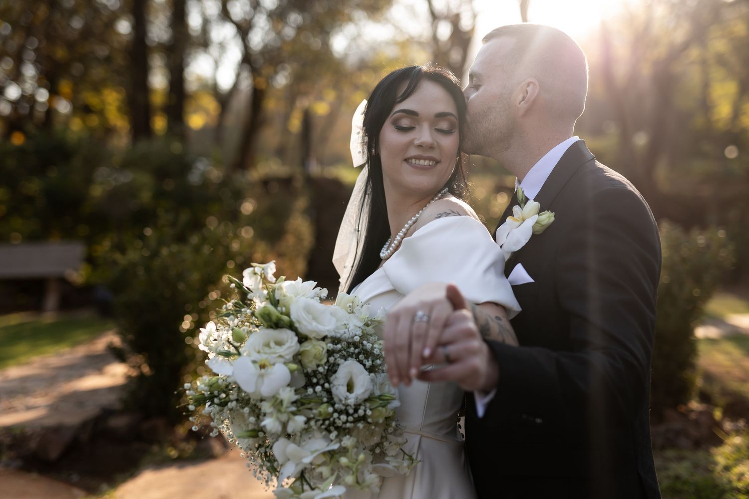 A romantic wedding photo set of a couple sharing tender moments in a sunlit garden during golden hour festivities.