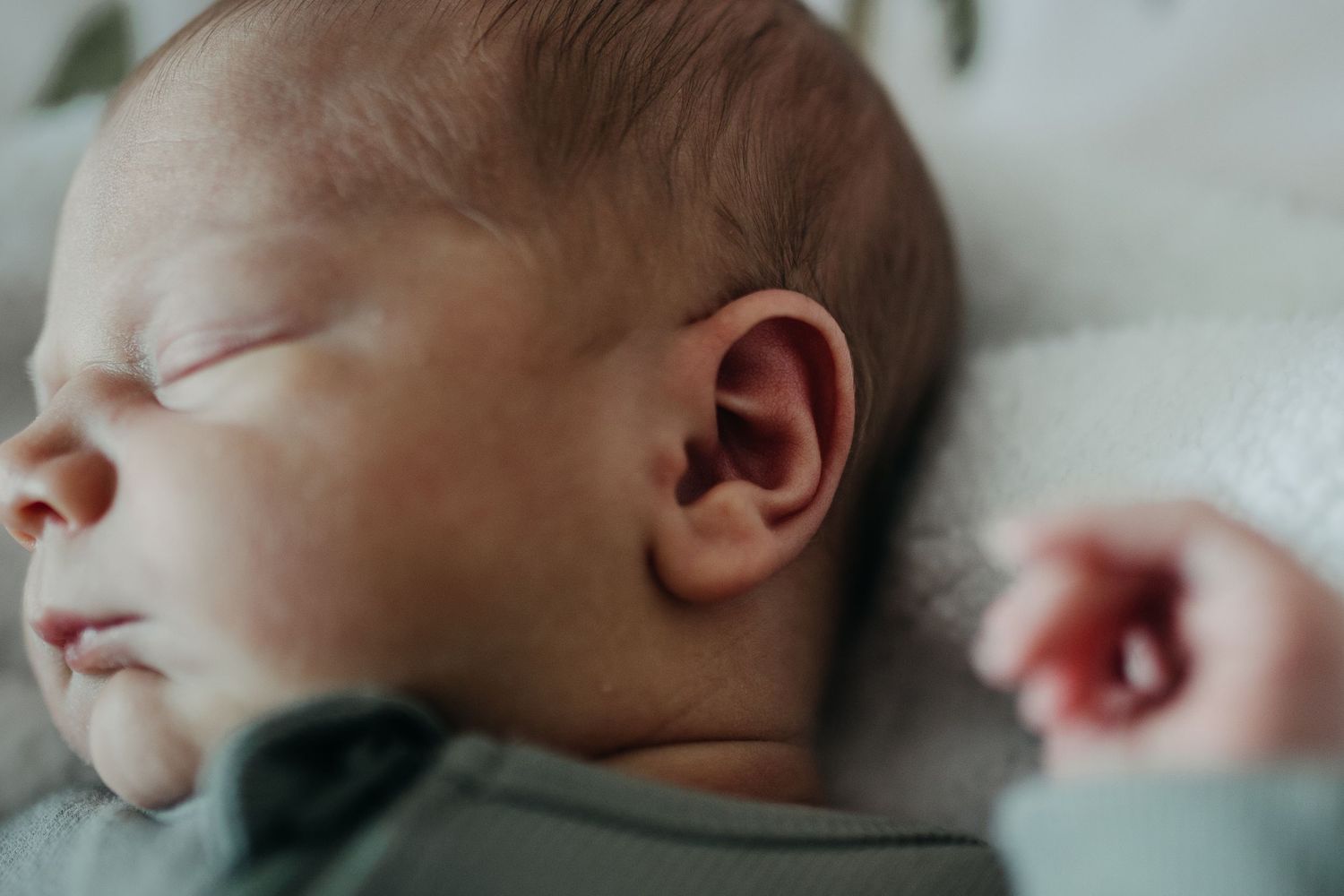 Collage of a sleeping newborn baby in soft focus wearing light colored clothing against neutral backgrounds.