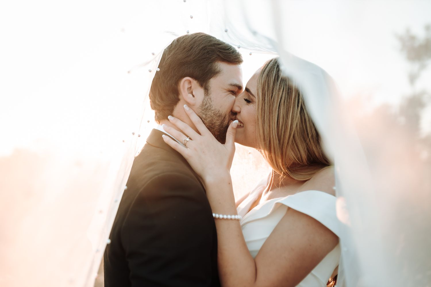 Intimate wedding portrait showing tender embrace between newlyweds in warm evening light.