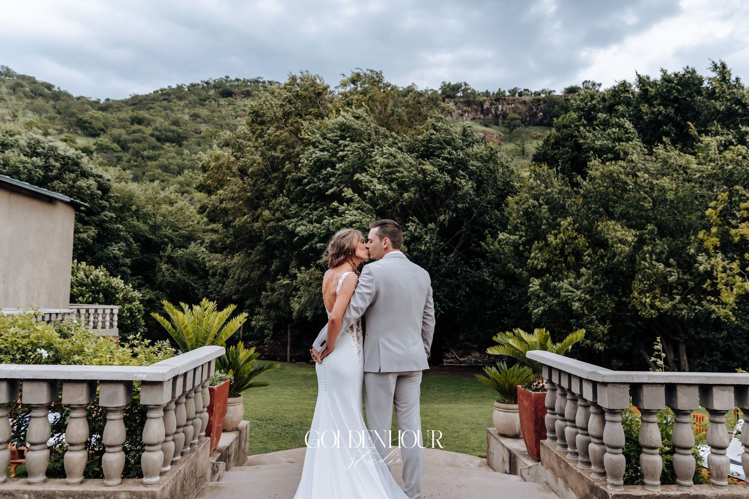 Scenic outdoor wedding venue with stone balustrades overlooking rolling hills and lush greenery.