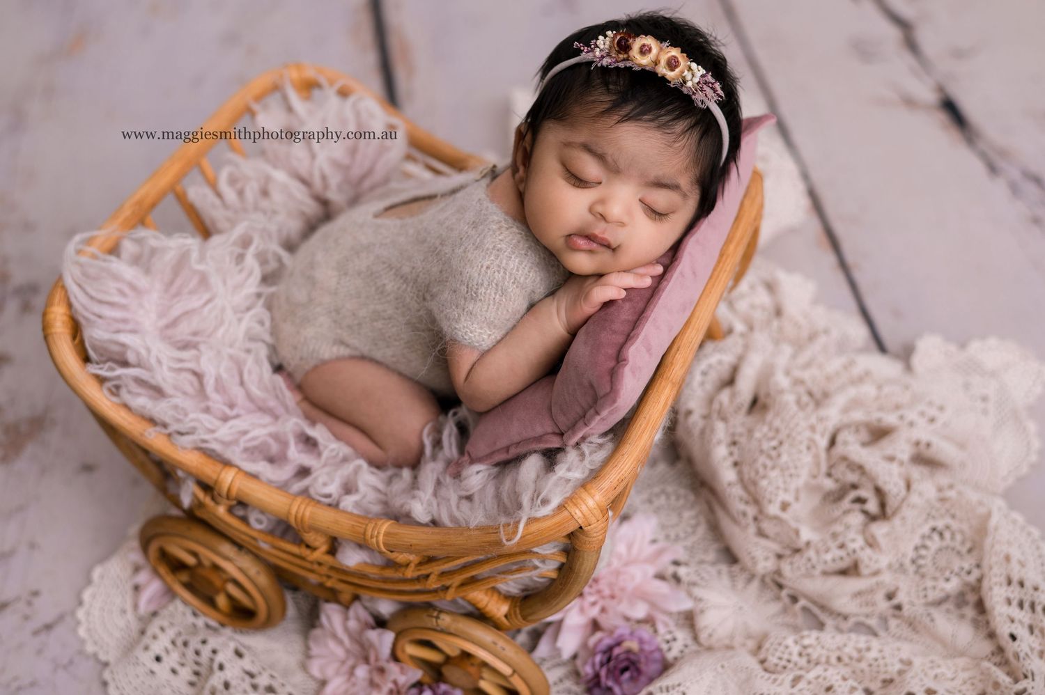 Sleeping newborn nestled in delicate lace blanket and wooden basket creates dreamy professional photo composition. Newborn photography