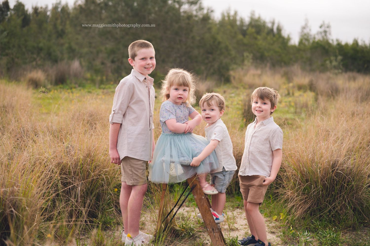 Family enjoying a tender moment together in a golden grass field during sunset.