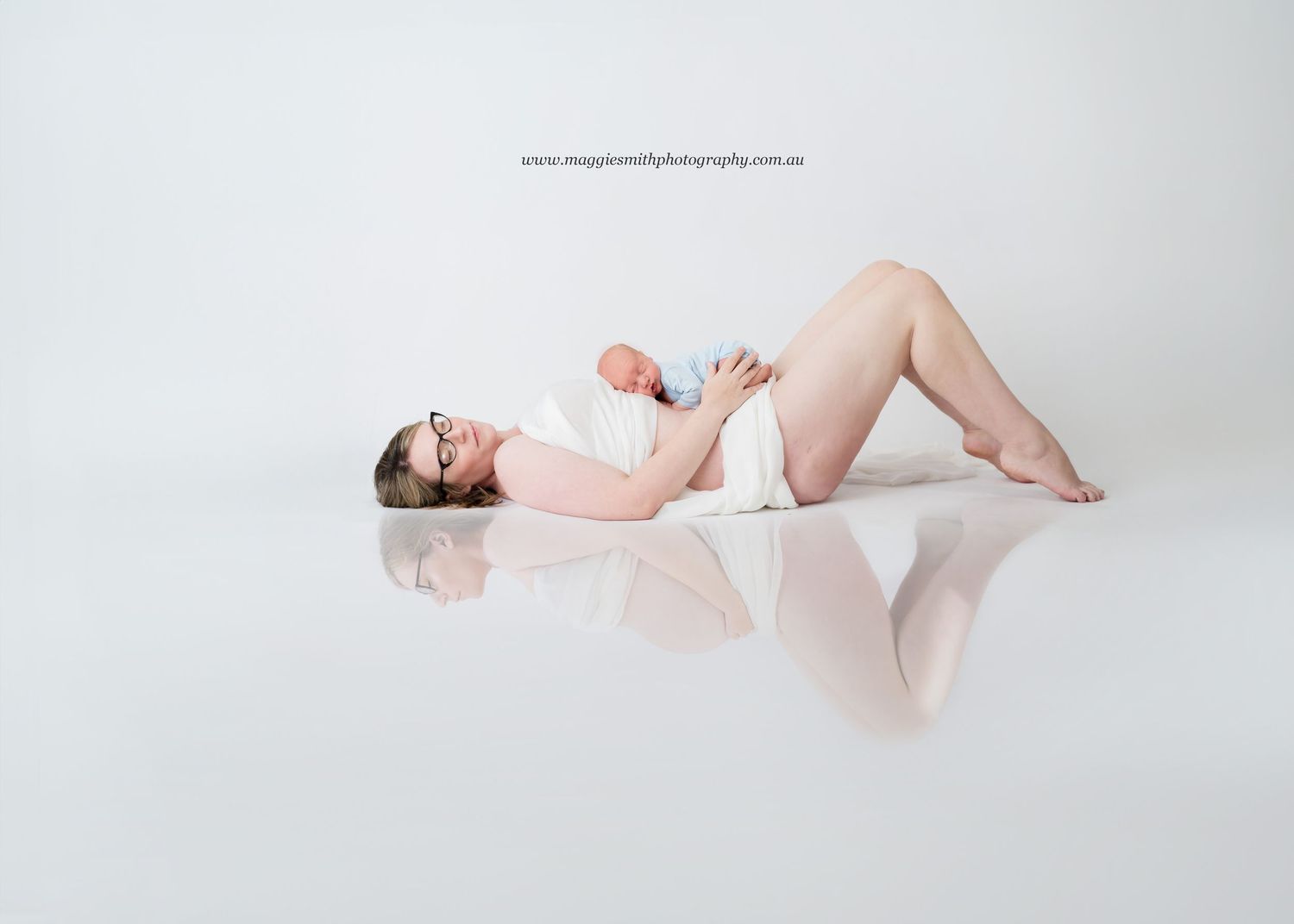 Maternity before and after shot in soft pink attire lying down on reflective white surface during studio photoshoot.