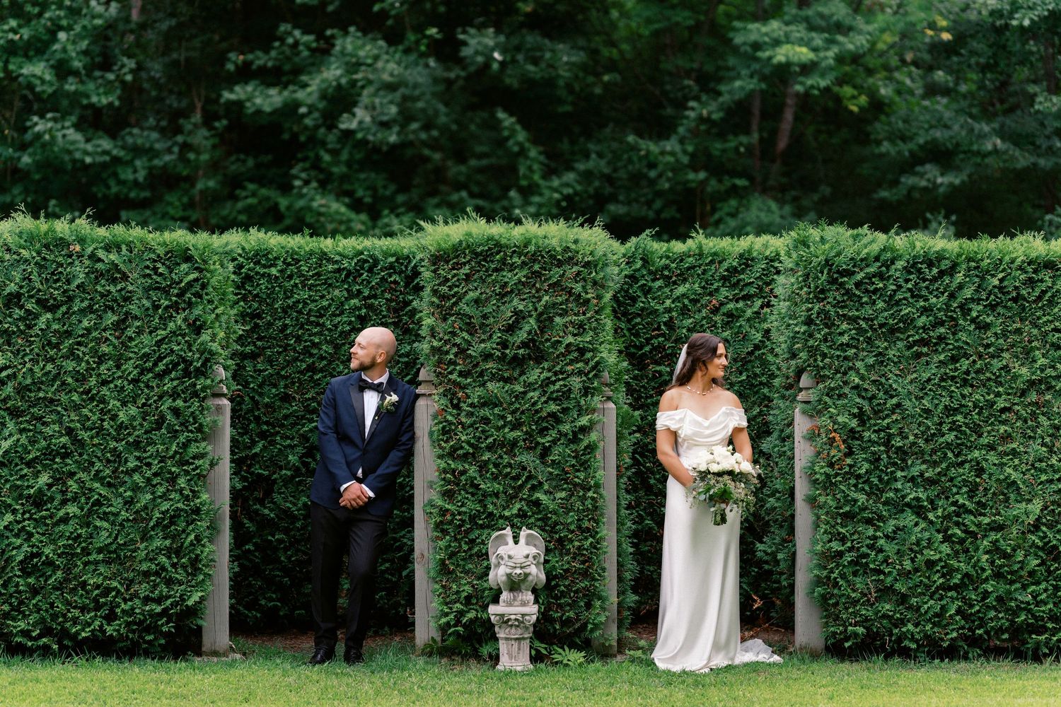 Elegant garden wedding ceremony setup with manicured hedges and natural greenery.