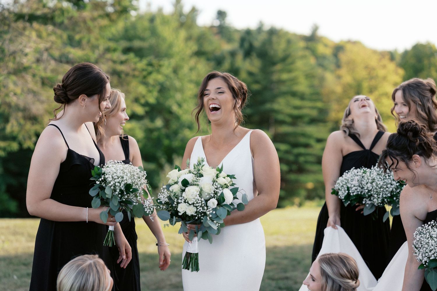 Wedding party laughs and celebrates together outdoors during autumn wedding festivities.