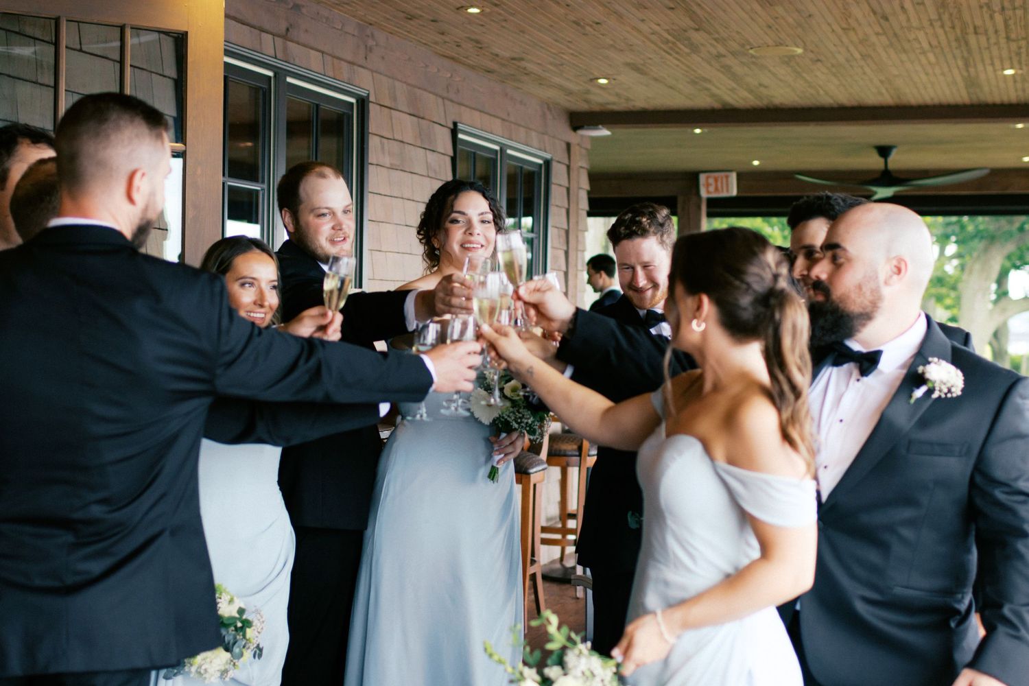 Wedding party members toasting and celebrating together at reception venue.