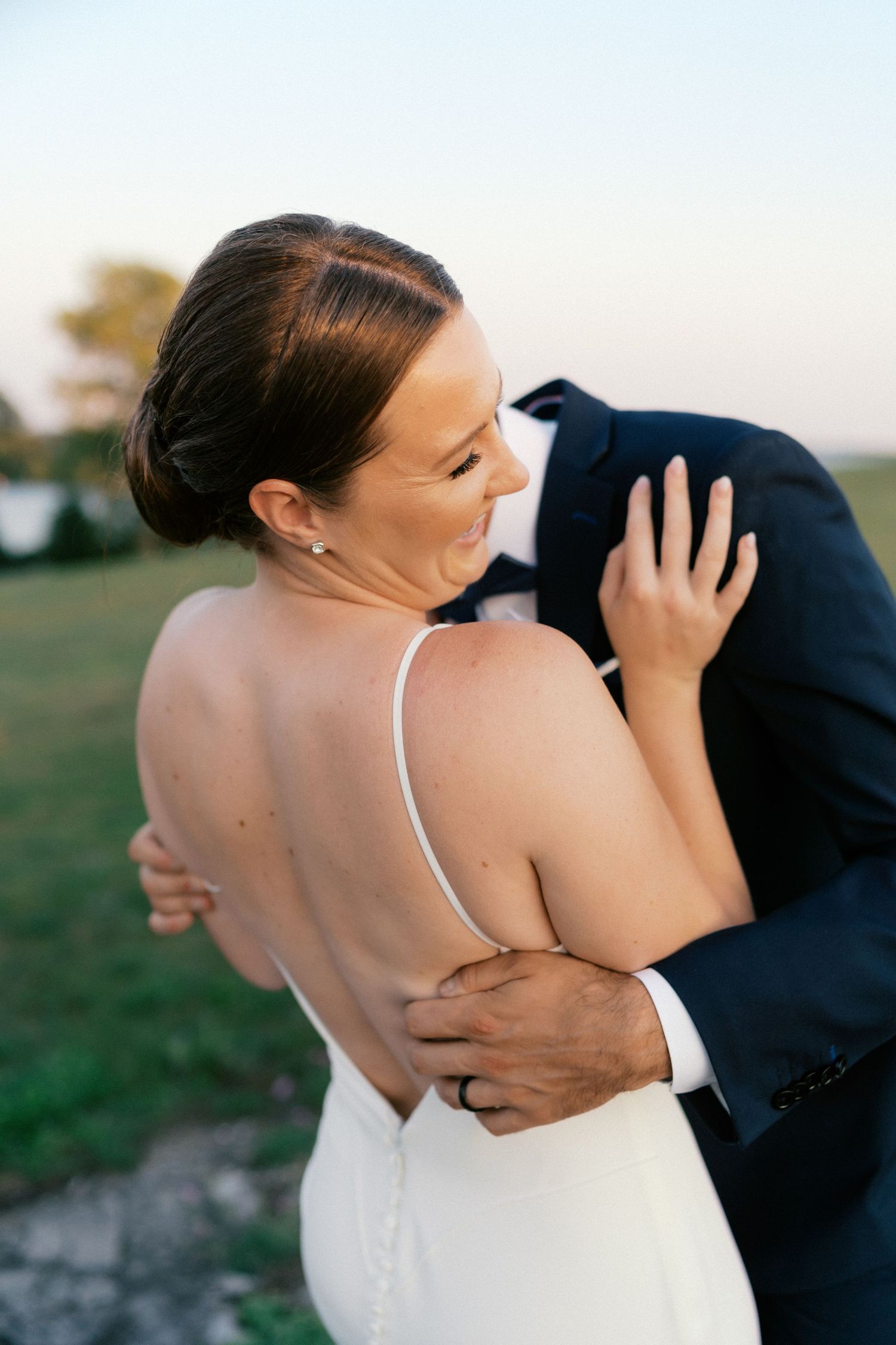 Intimate embrace between couple during sunset wedding photoshoot.