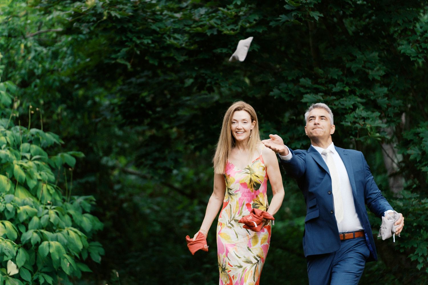 Wedding guests enjoy candid moments during an outdoor summer celebration.