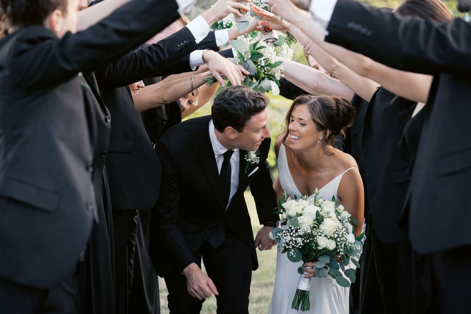 Wedding party celebrating with drinks outdoors during a photo session.