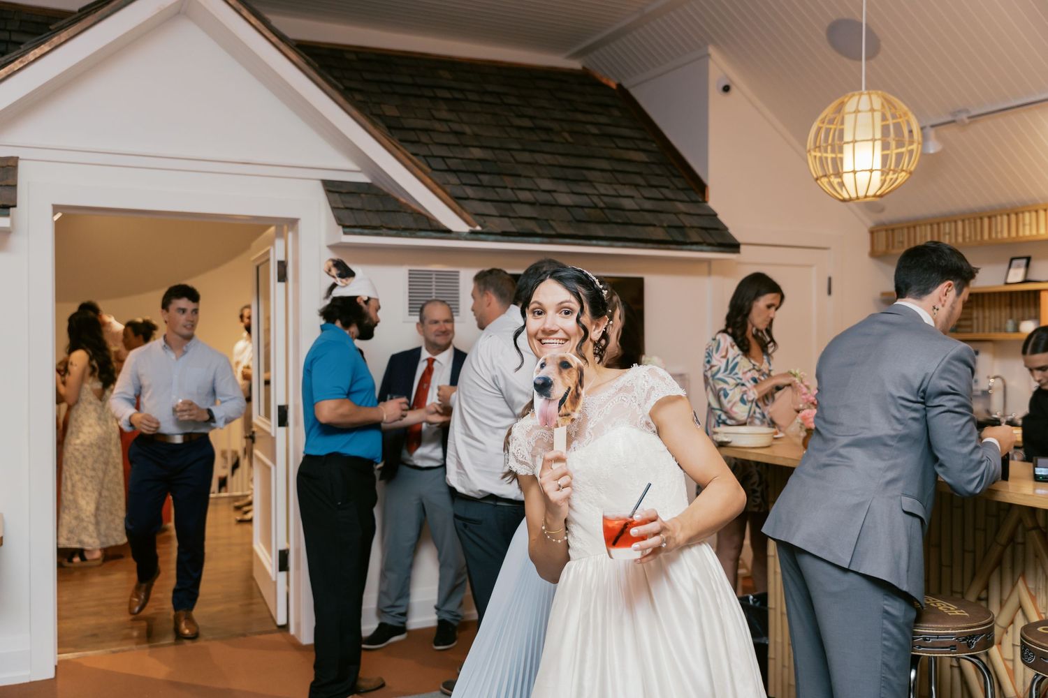 Wedding reception guests dancing and celebrating in rustic indoor venue.
