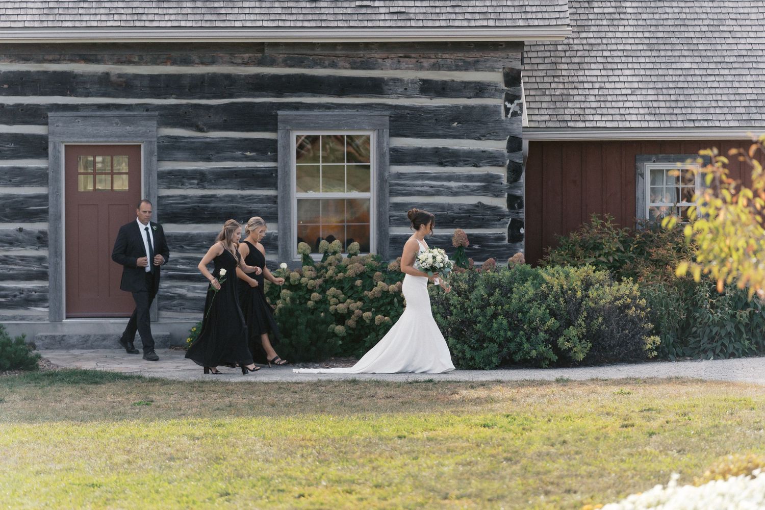 Historic log cabin buildings with wooden porches and windows in a rustic setting.