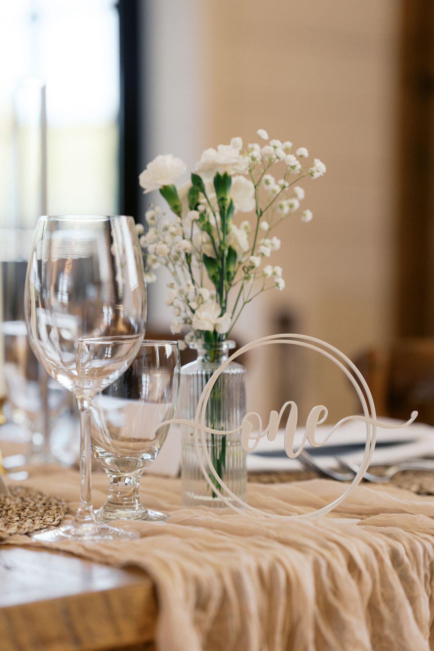 Elegant table setting with delicate baby's breath flowers in glass vases and white table linens.