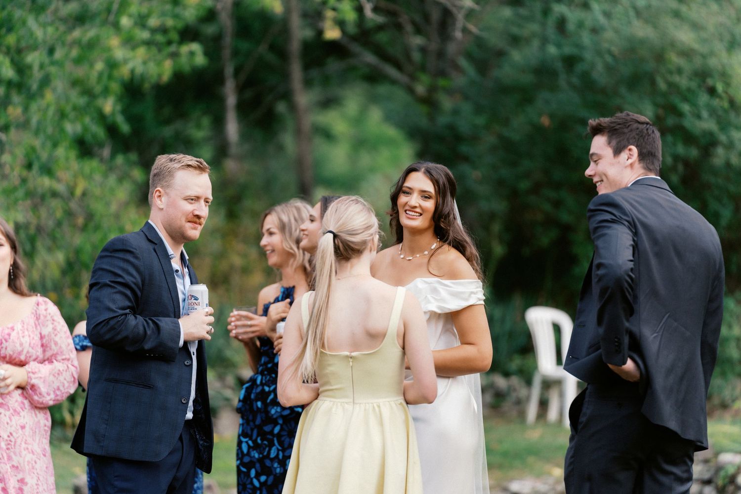Wedding guests mingling during an outdoor garden reception with formal attire.