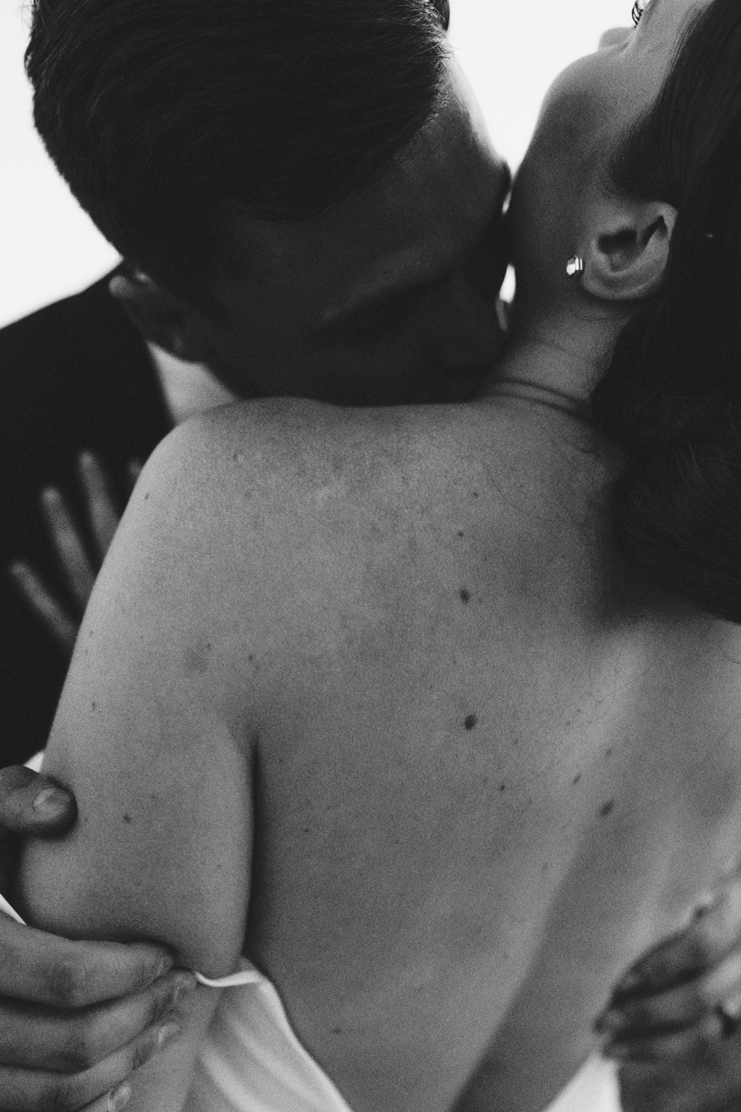 Romantic black and white photograph capturing an intimate moment between two lovers in an embrace.