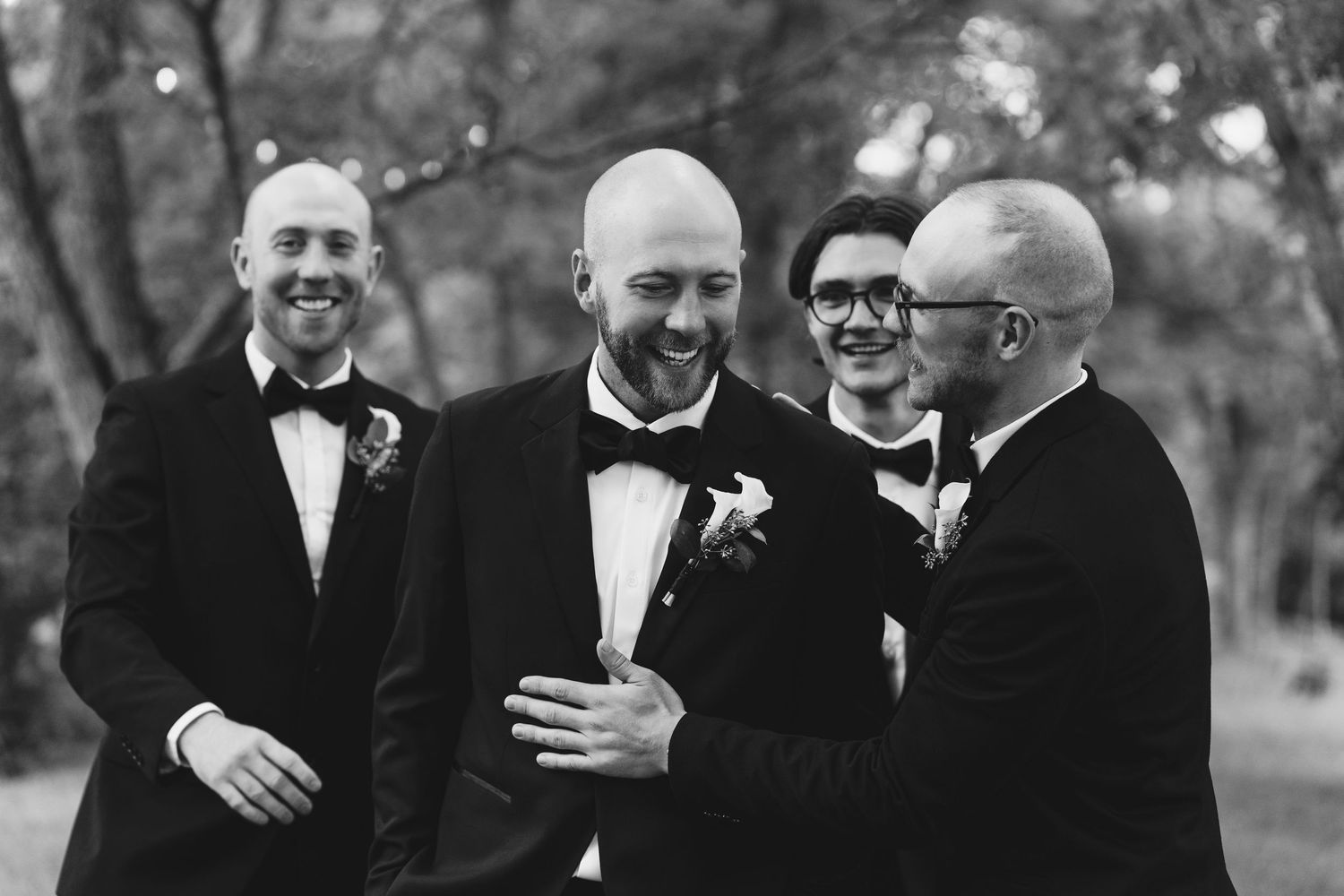 A black and white wedding photo series showing joyful moments between guests and wedding party members at an outdoor venue.