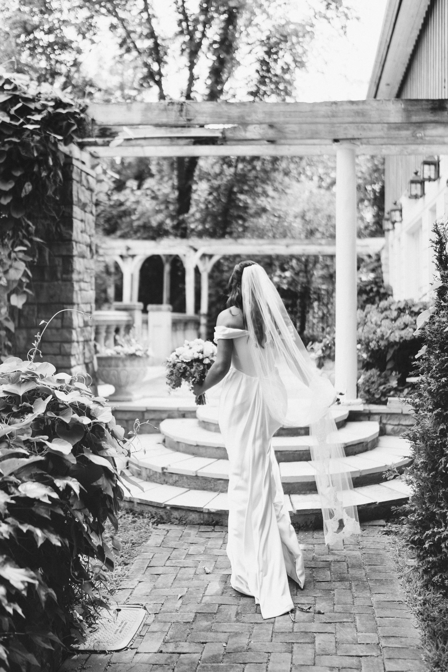A series of artistic black and white photos showing a person in white flowing dress twirling on a brick patio.