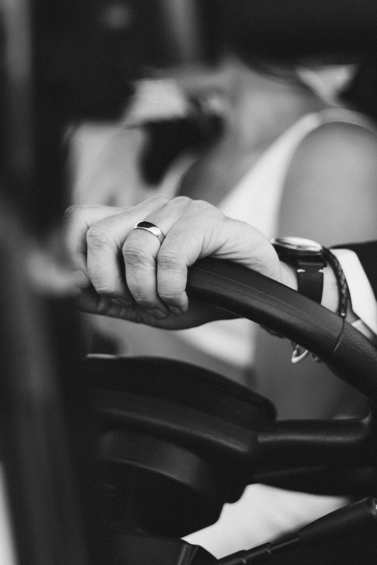 Close-up black and white shot of hands pouring champagne into glasses.