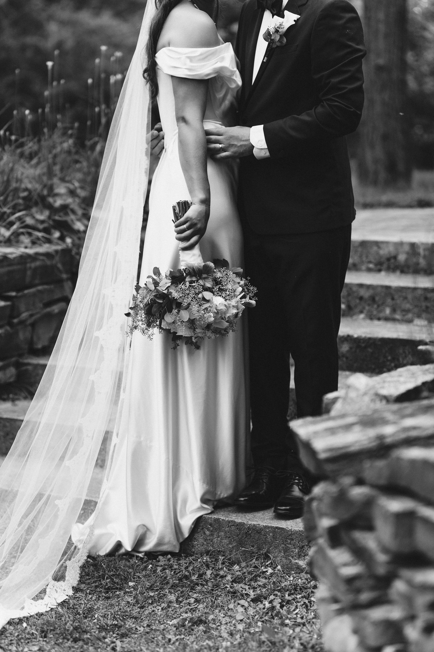 Black and white wedding portraits showing flowing dress details and intimate moments.