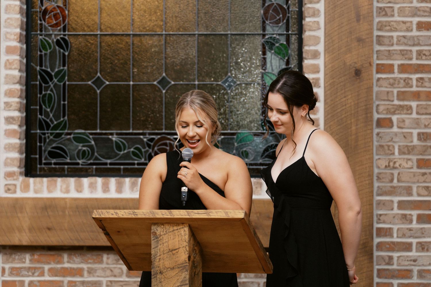 Wedding celebration in a rustic brick-walled venue with wooden tables and decorative details.