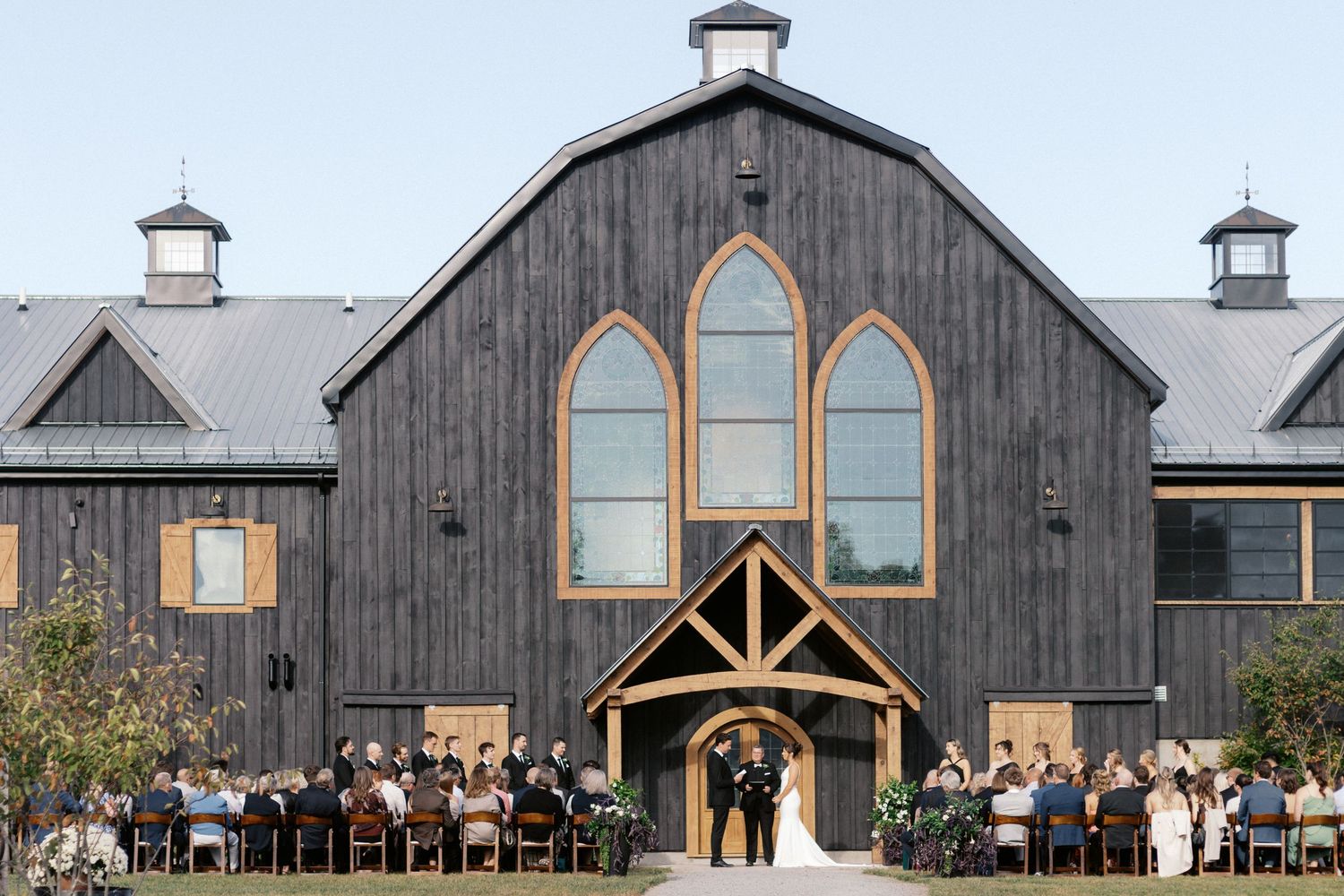 Rustic barn wedding venue with arched windows and wooden exterior.