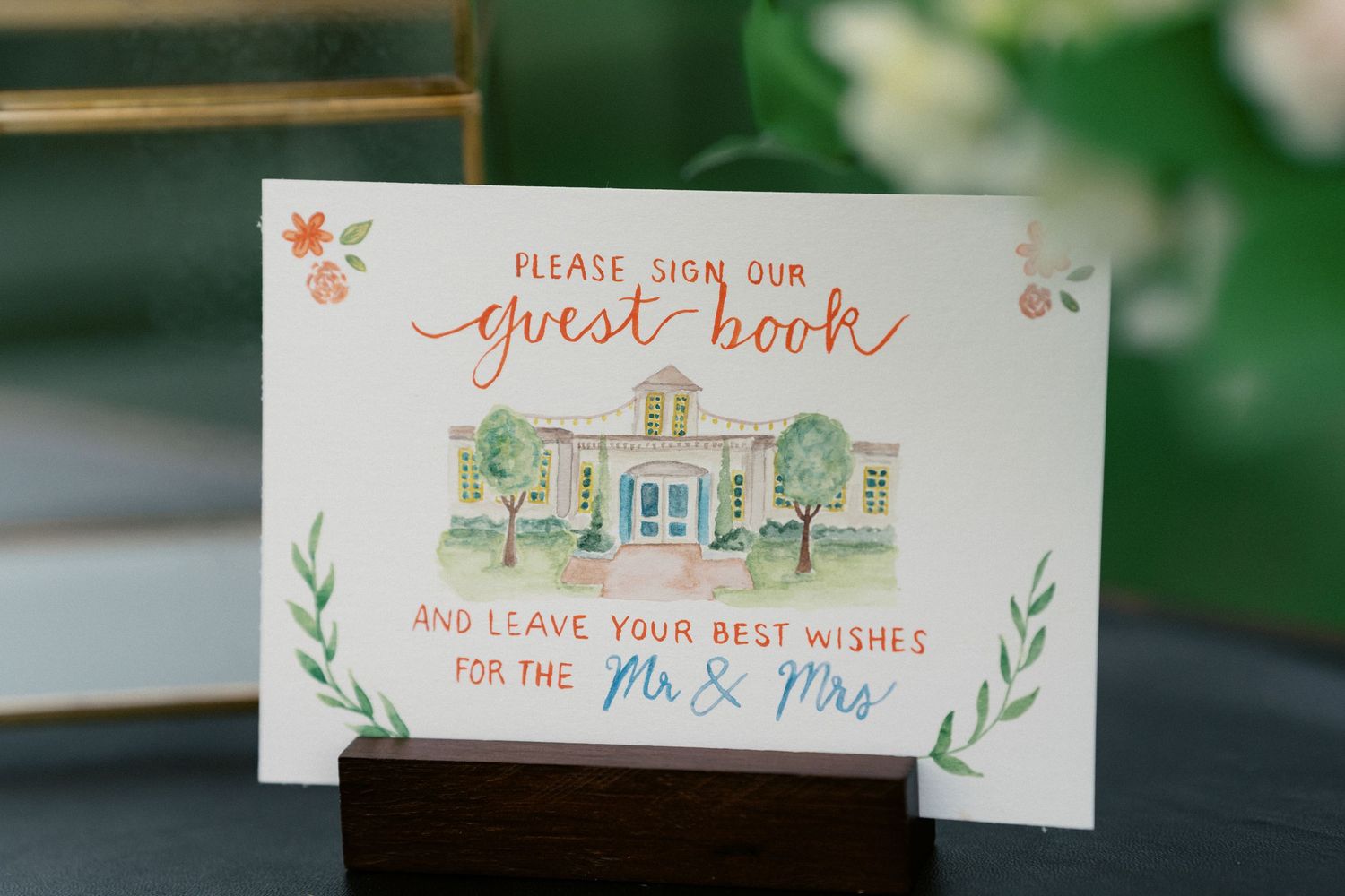Delicate watercolor wedding place cards featuring a house illustration and green botanical details.