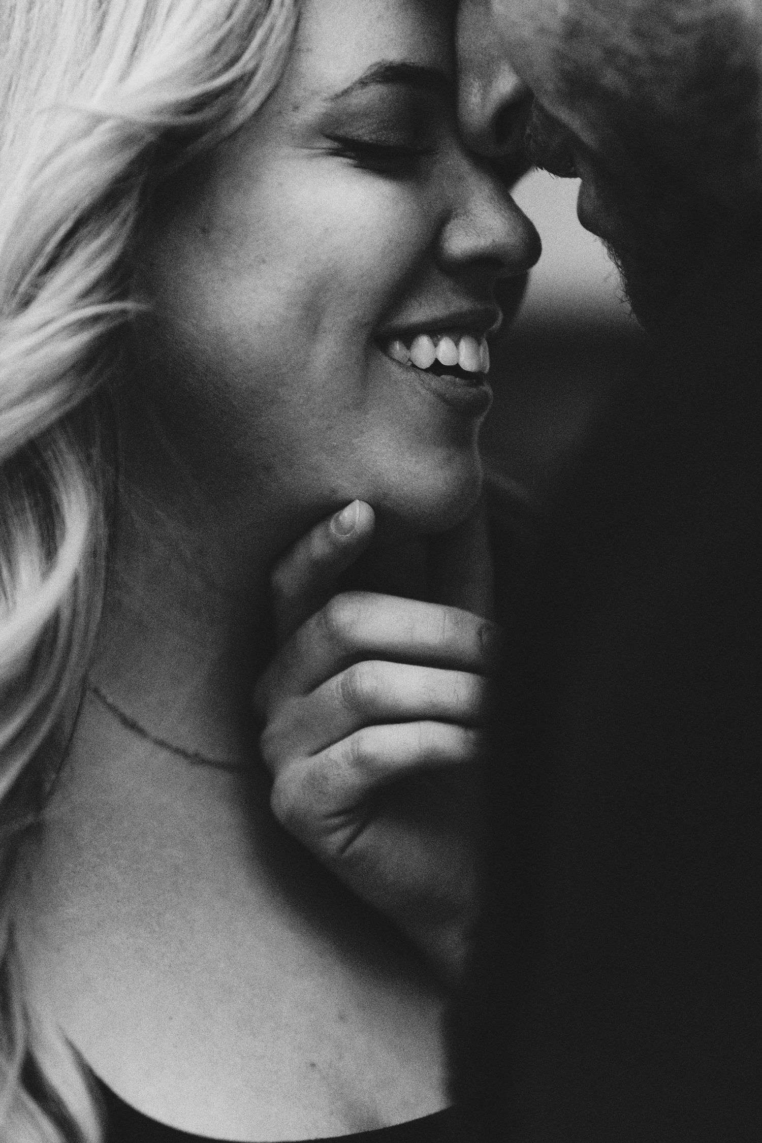 Black and white portrait capturing a joyful intimate moment between two people.