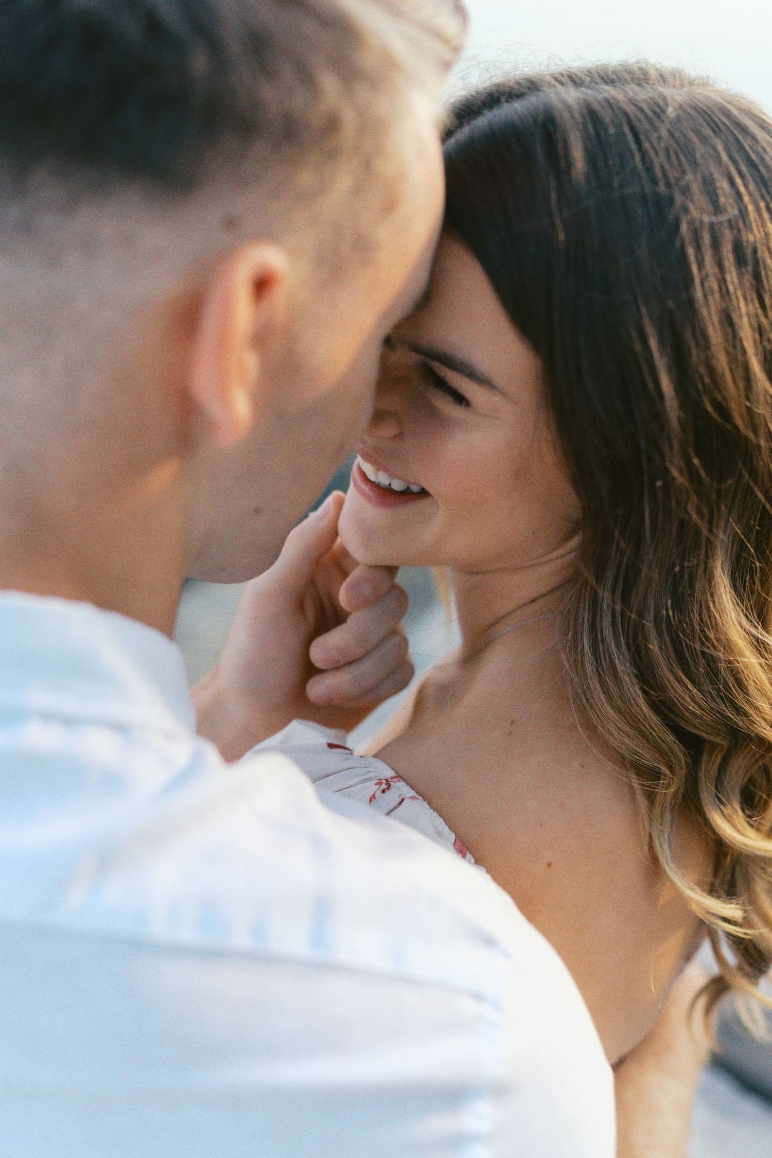 Intimate couple moment captured in golden sunlight during outdoor photoshoot.
