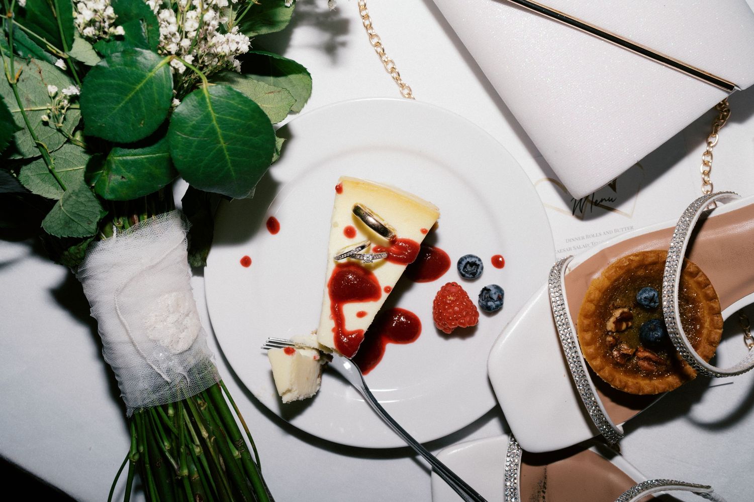 Wedding reception table with partially eaten dessert plates and floral decorations.