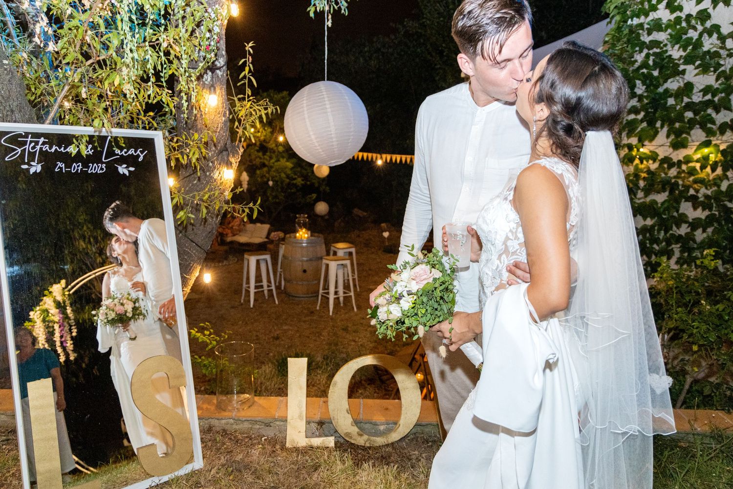 Evening wedding reception with glowing lanterns and romantic lighting outdoors.