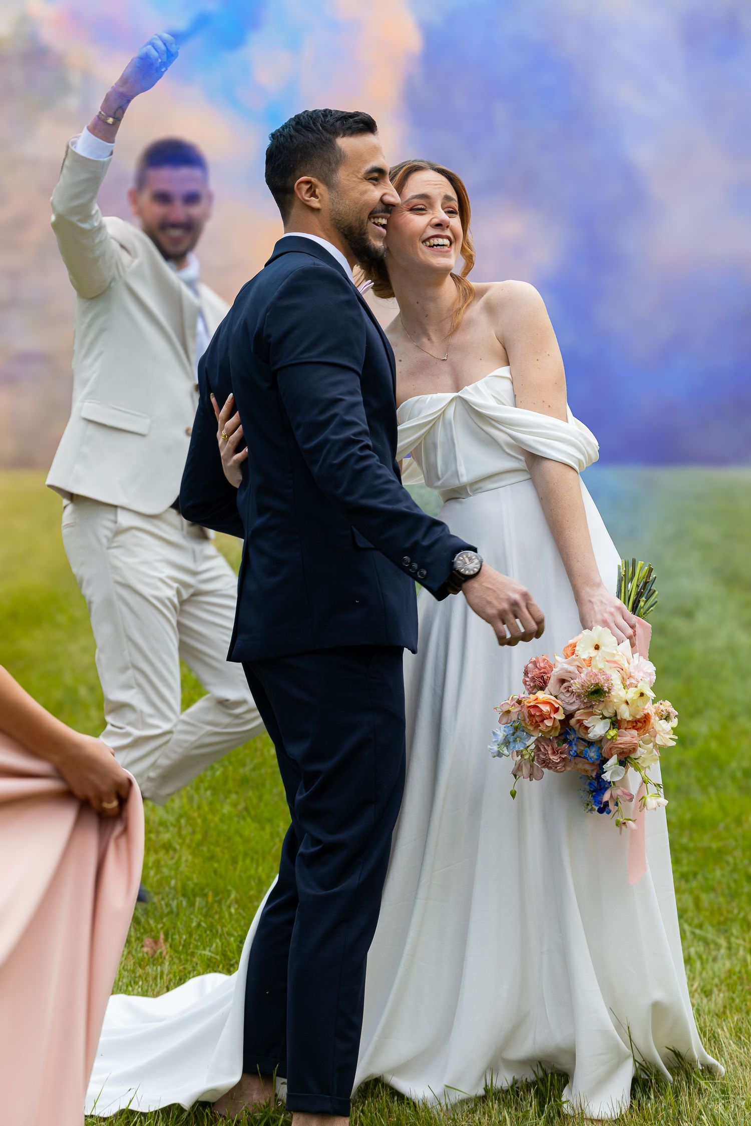 Wedding celebration on lush green lawn with pink and white attired wedding party.