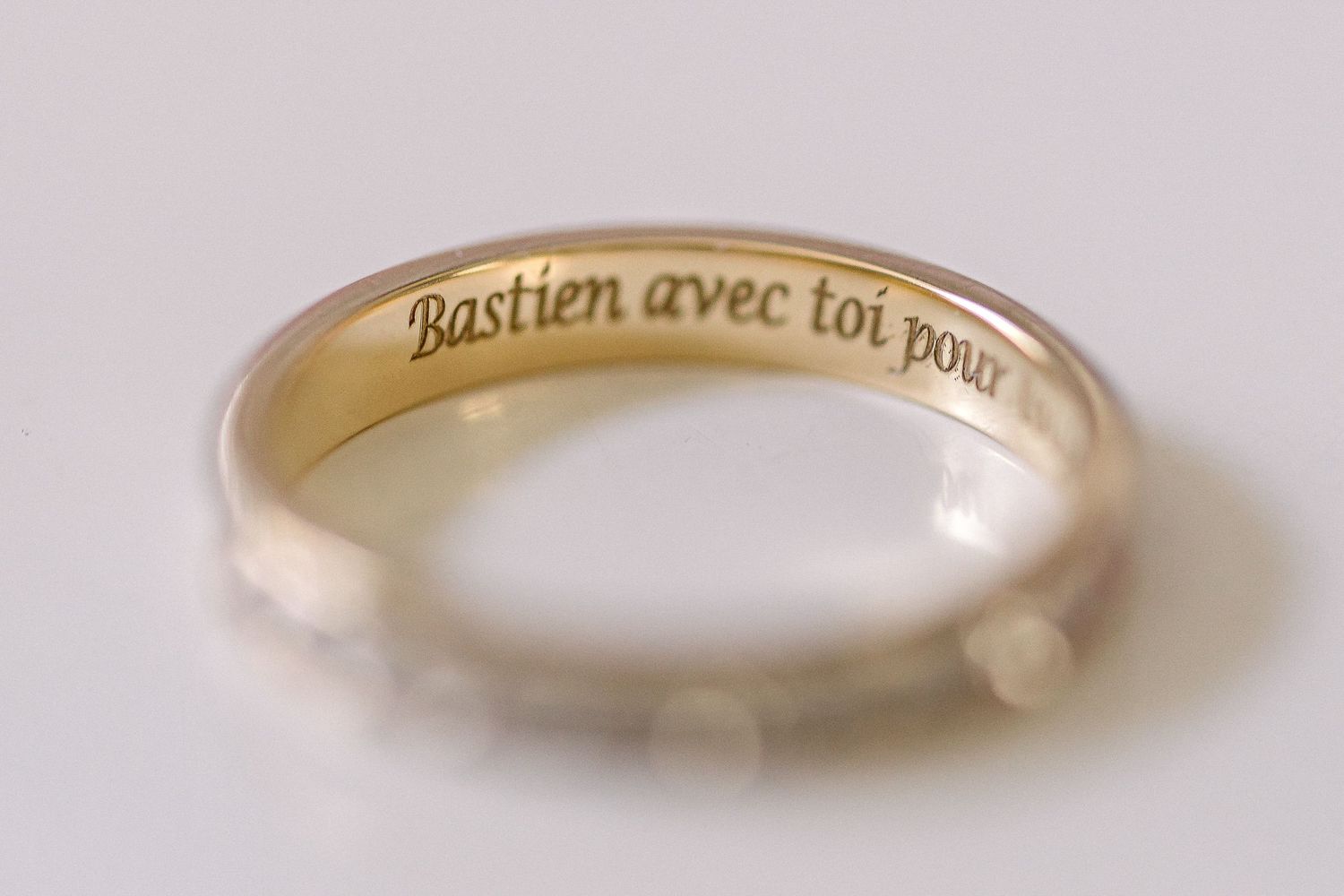 Wedding rings with engraved text photographed in soft focus.