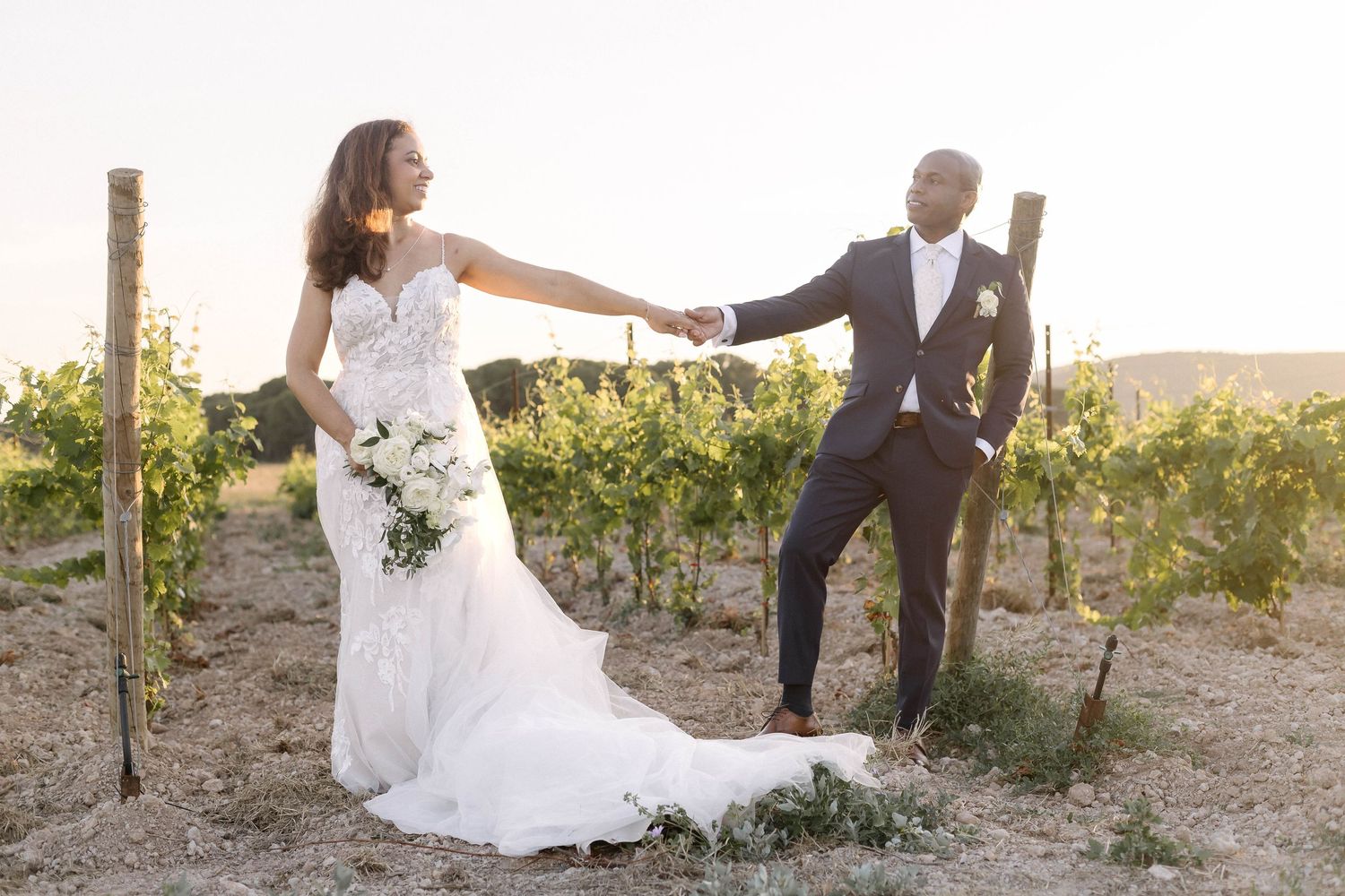 Newlyweds share intimate moments in a beautiful outdoor winery setting at golden hour.