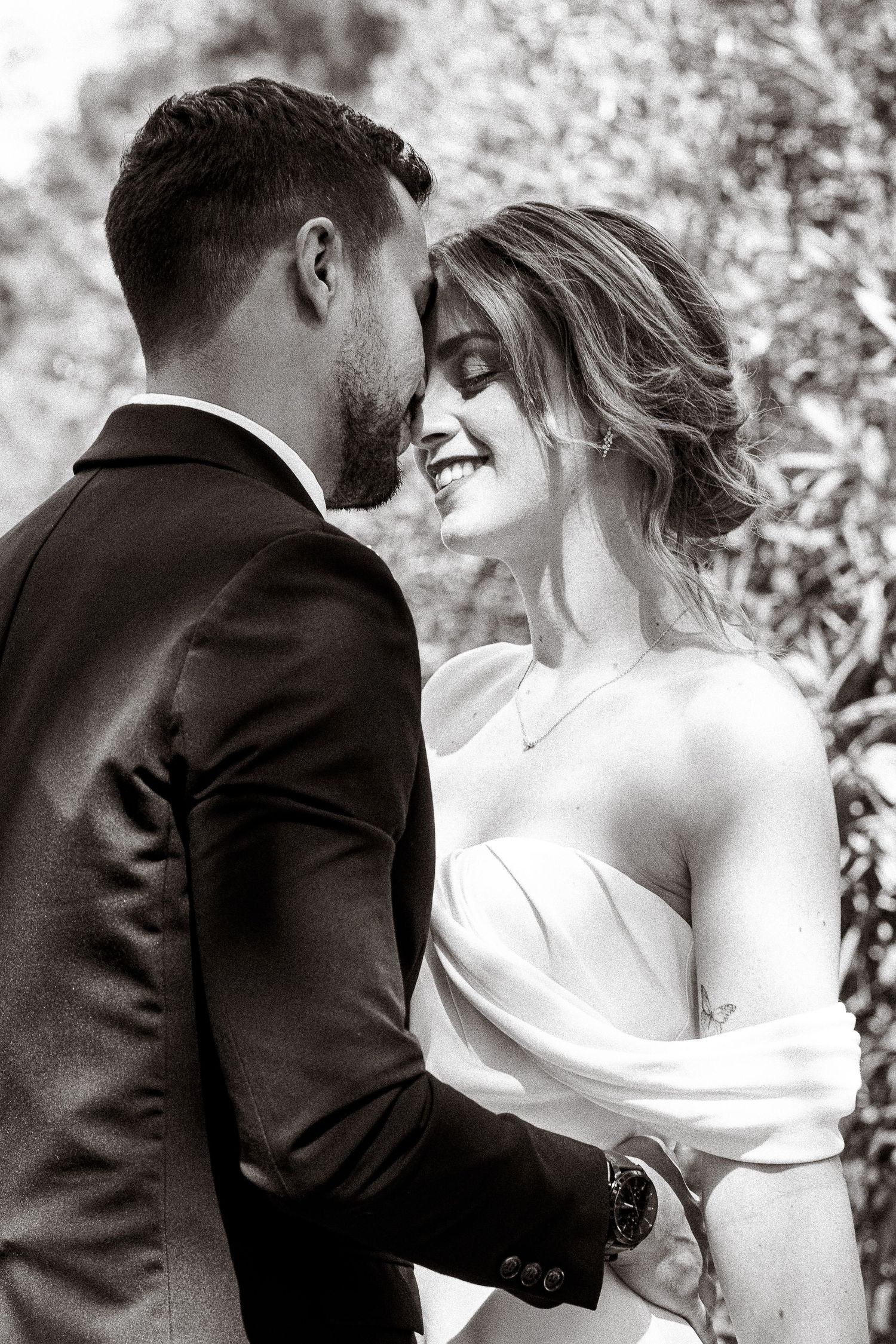 Intimate black and white wedding portrait of a couple sharing a tender moment together.