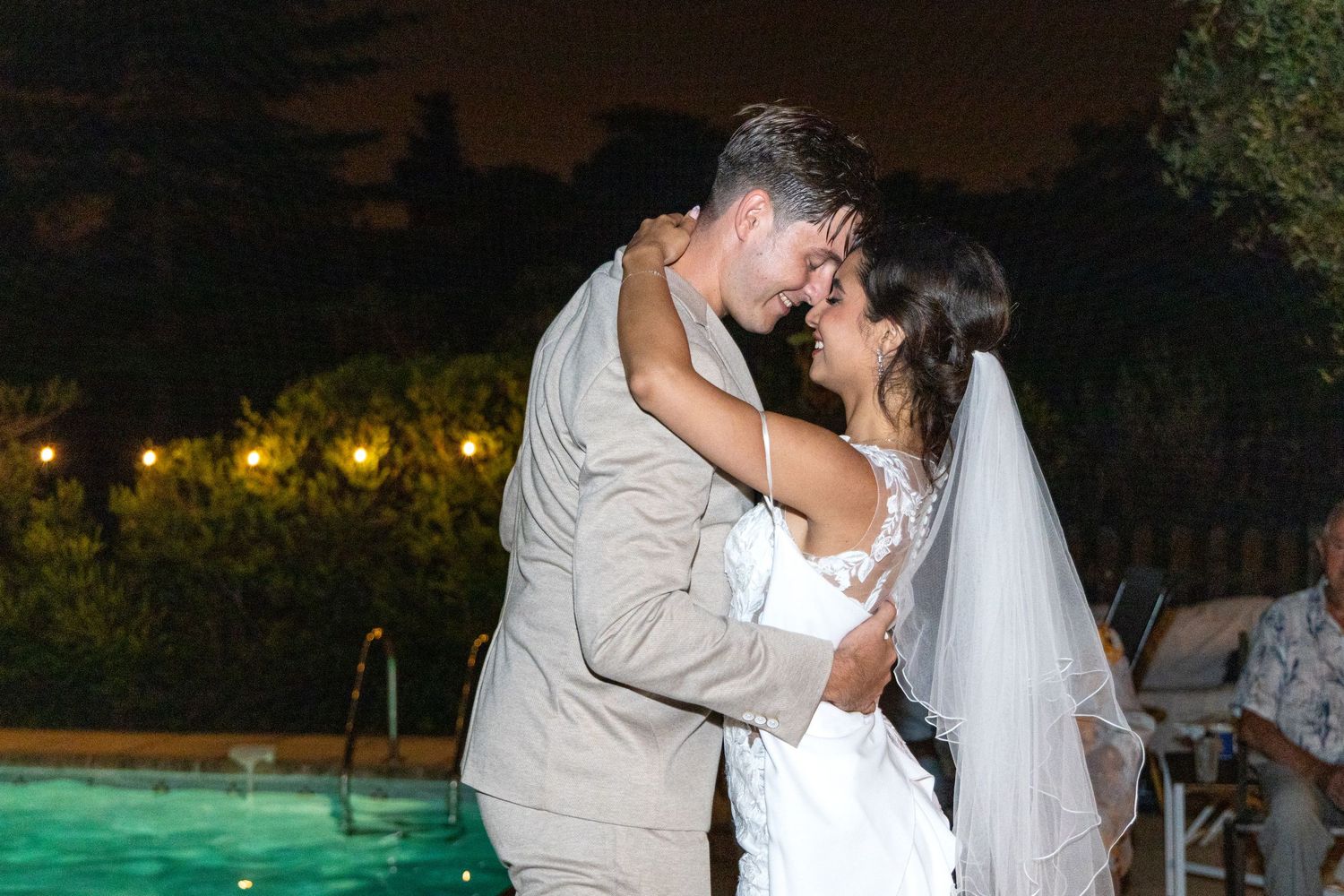 Romantic nighttime wedding celebration with string lights and outdoor decor.