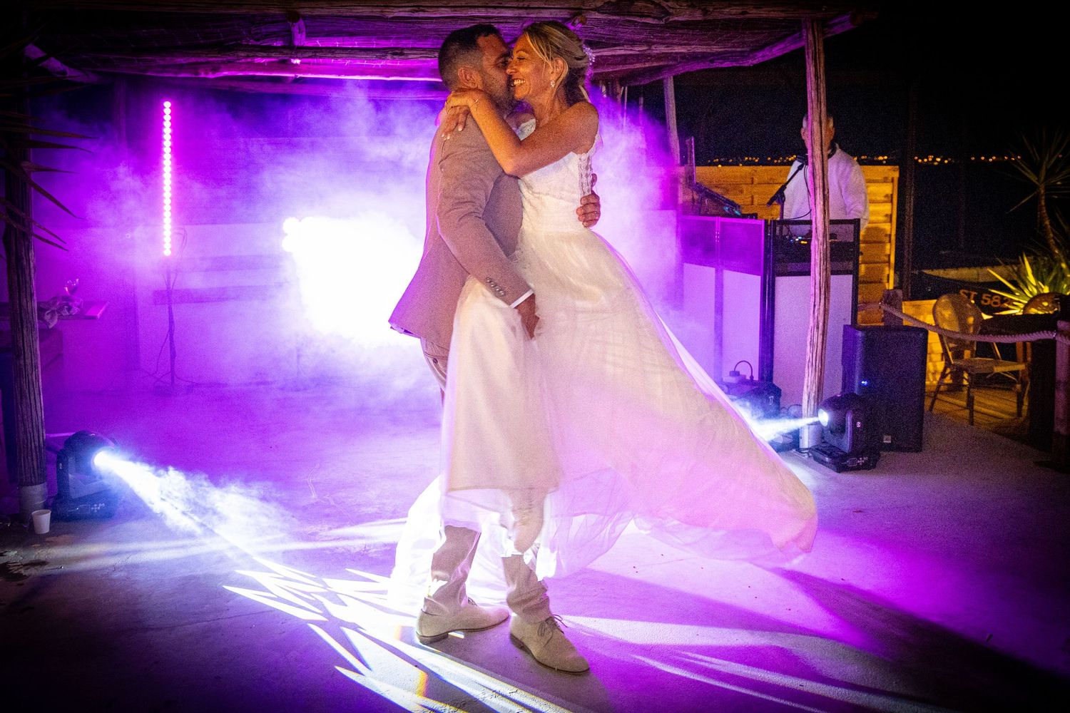 Couple dancing in purple-lit venue creating dramatic silhouettes.