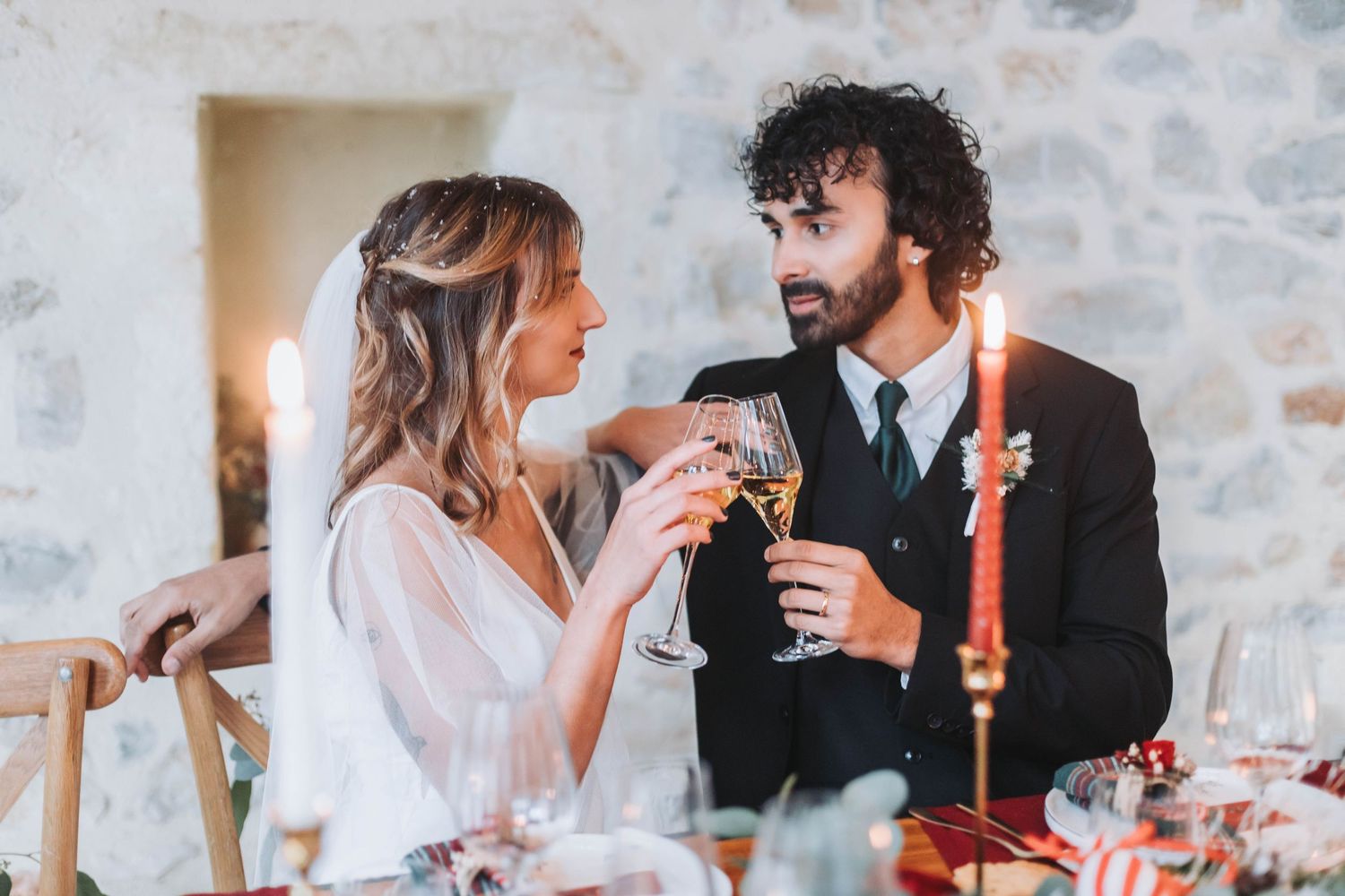 Joyful couple enjoying champagne and laughter at their wedding reception.