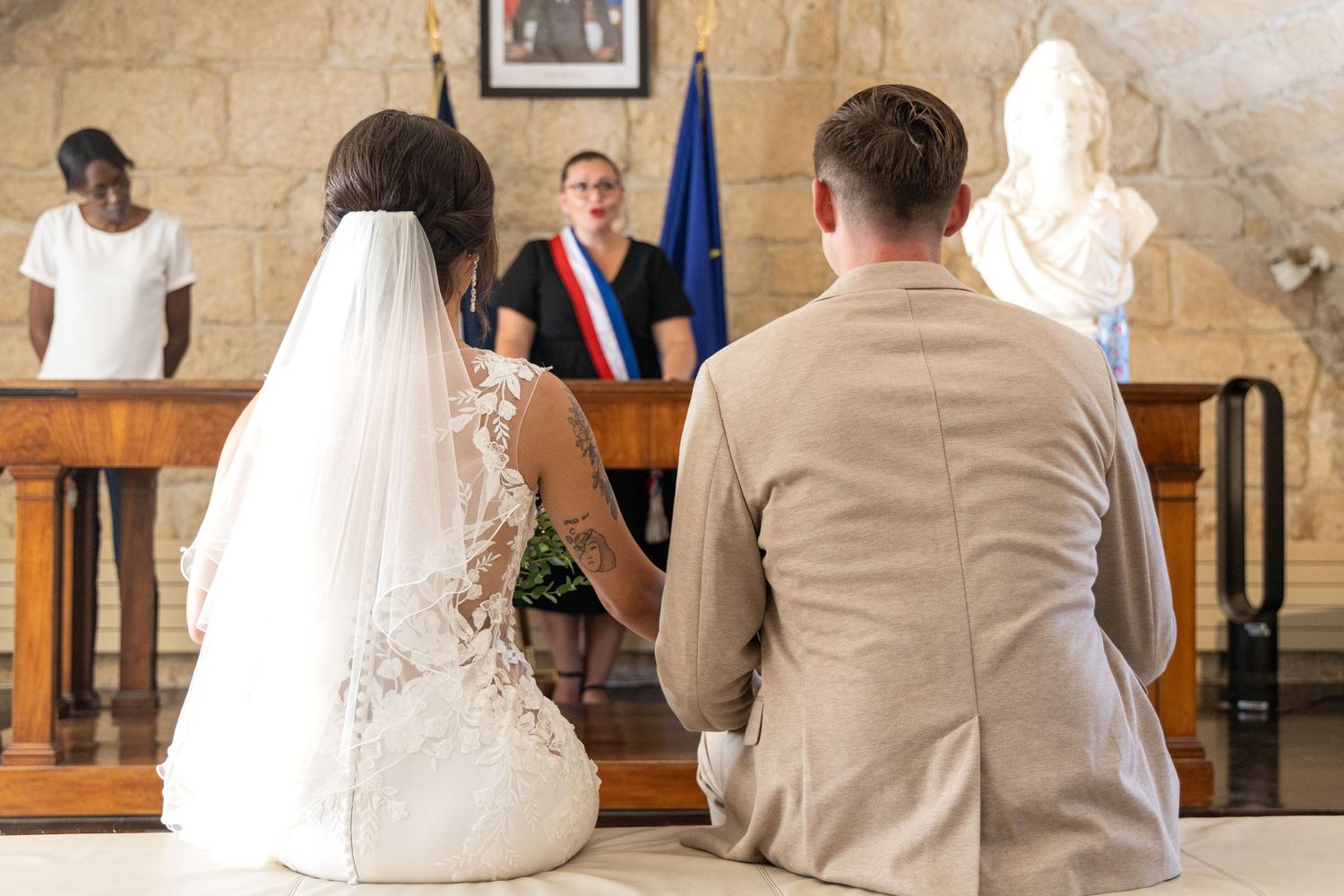 Civil wedding ceremony with official proceedings in historic stone building.