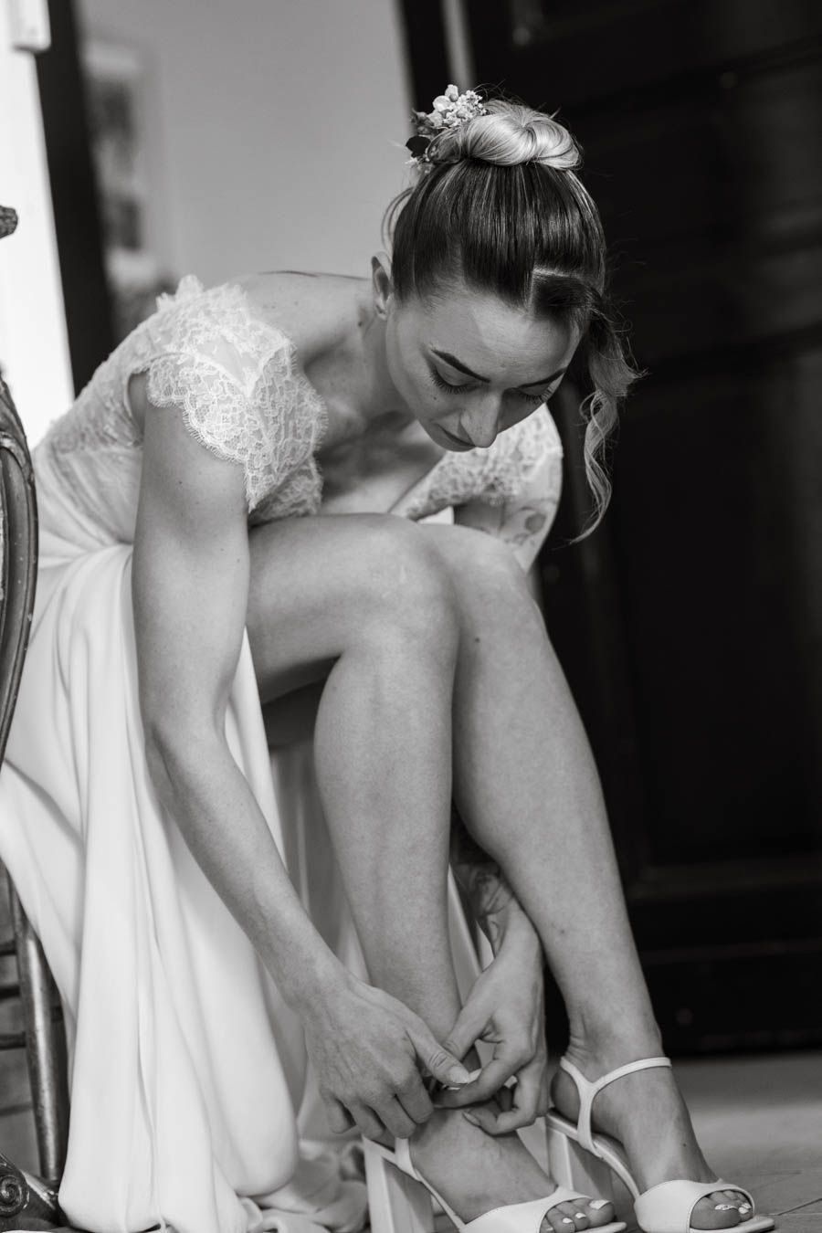 Wedding preparations showing detailed lace shoes being fastened.