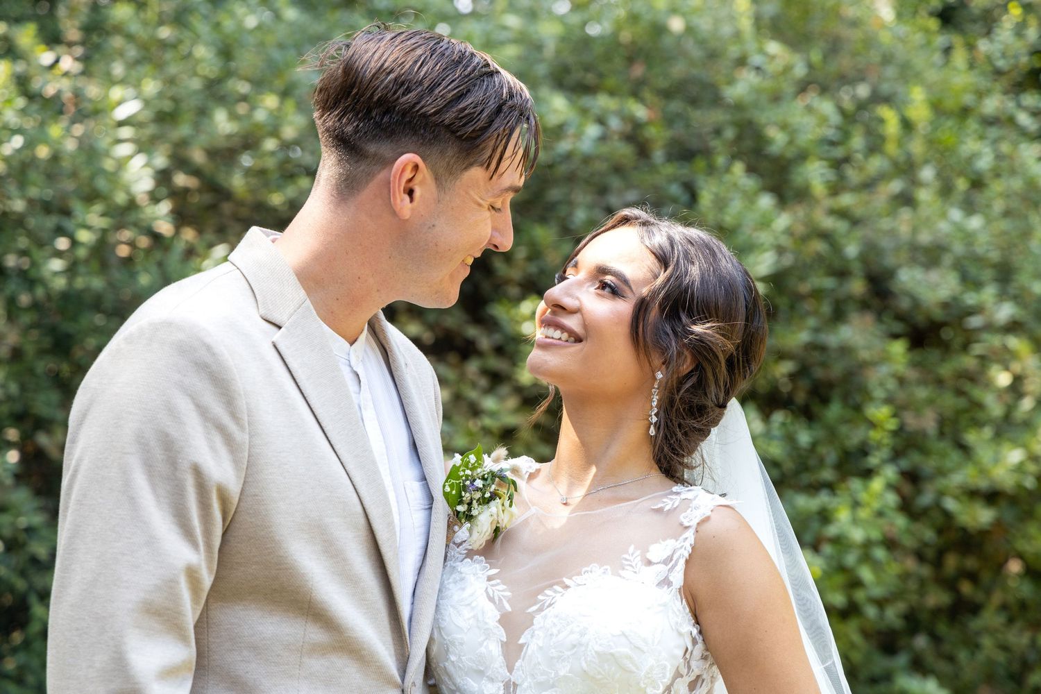 Candid wedding portraits capturing natural laughter in a garden setting.