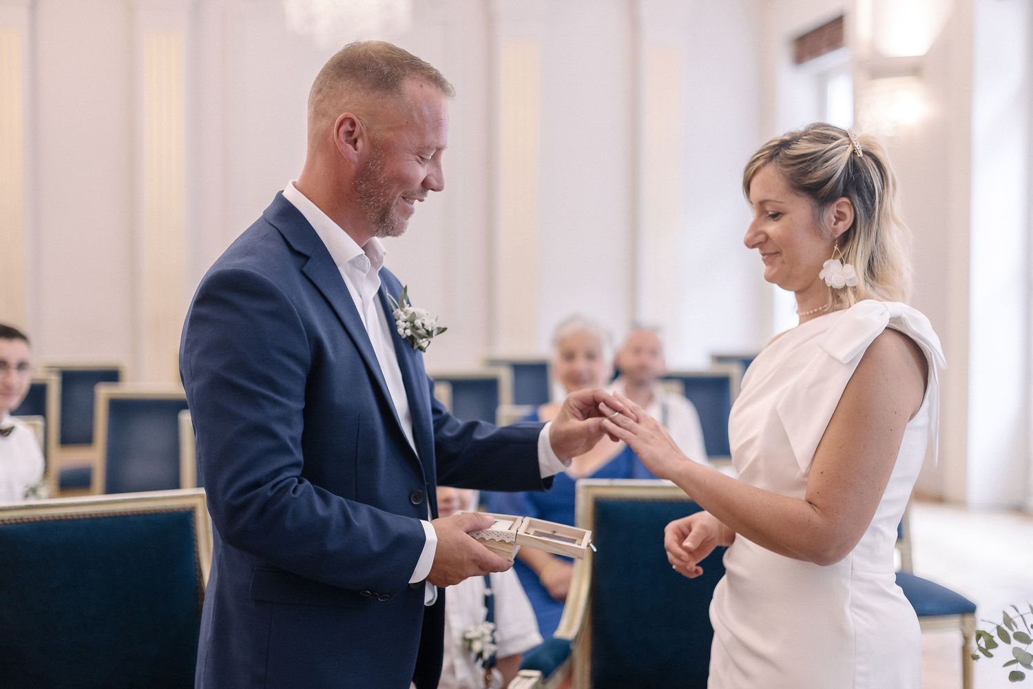 A couple exchanges rings during an intimate indoor wedding ceremony while standing in a church.