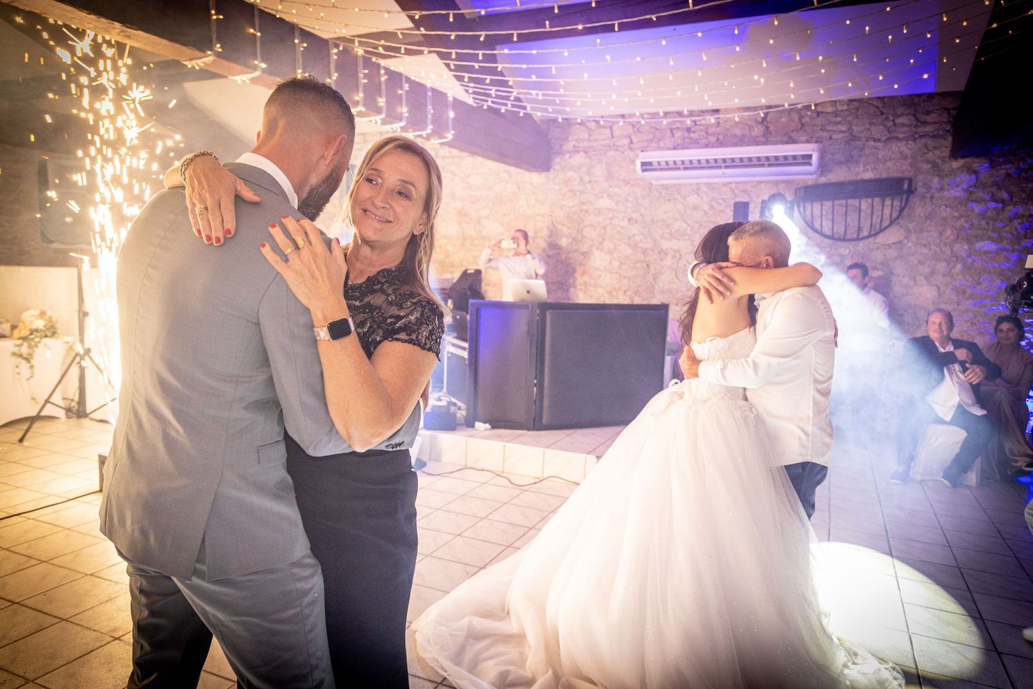 Wedding dance floor moments with sparkler effects and ambient lighting creating magical atmosphere.
