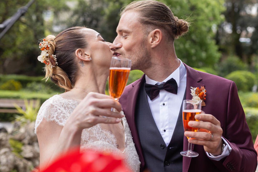 Formal garden wedding reception with guests sharing drinks and smiles.